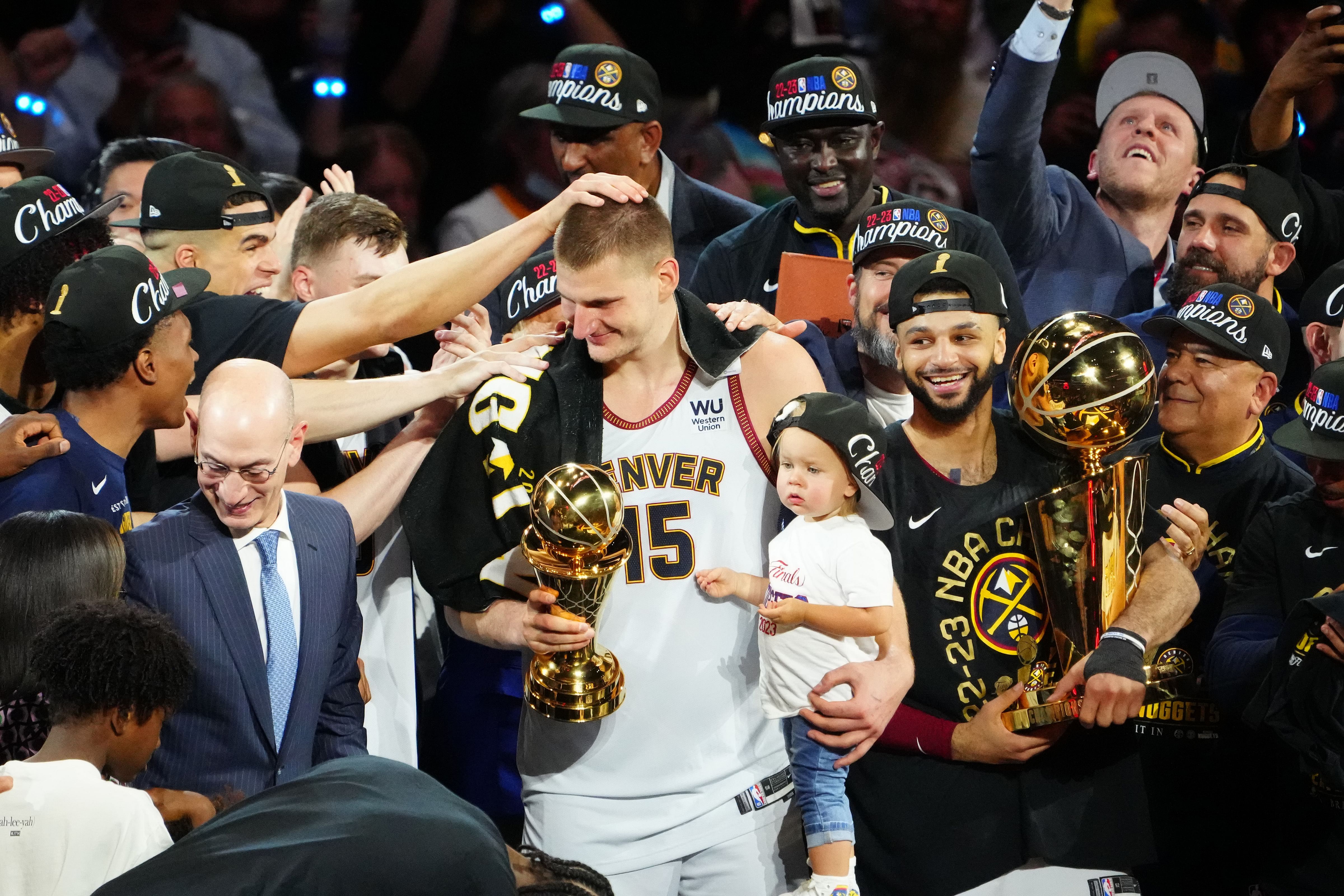 Denver Nuggets center Nikola Jokic (15) holds his daughter as he celebrates winning the Bill Russell NBA Finals MVP Award. Photo Credit: Imagn