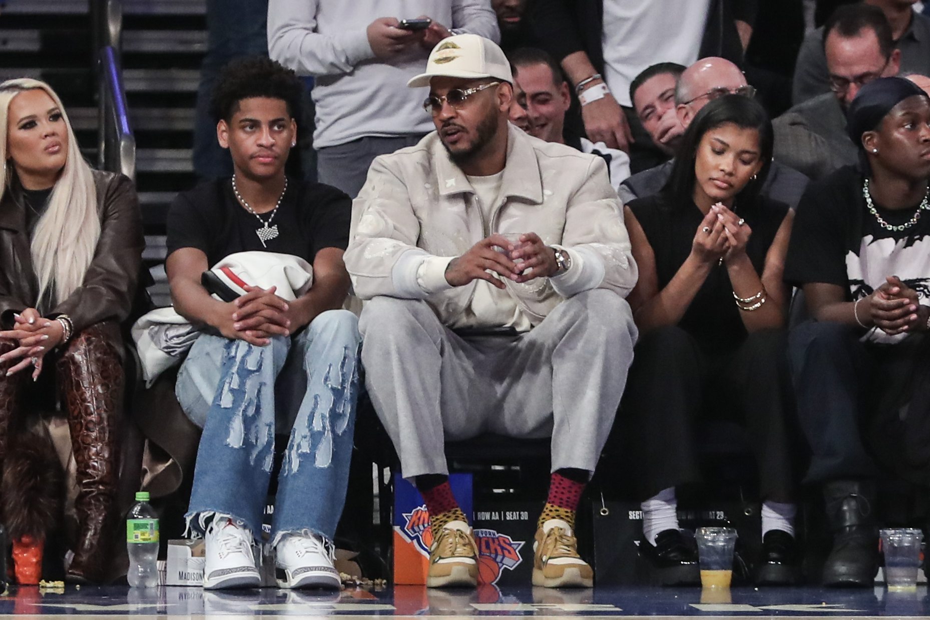 Former NBA player Carmelo Anthony sits with his son Kiyan Anthony at Madison Square Garden. Photo Credit: Imagn