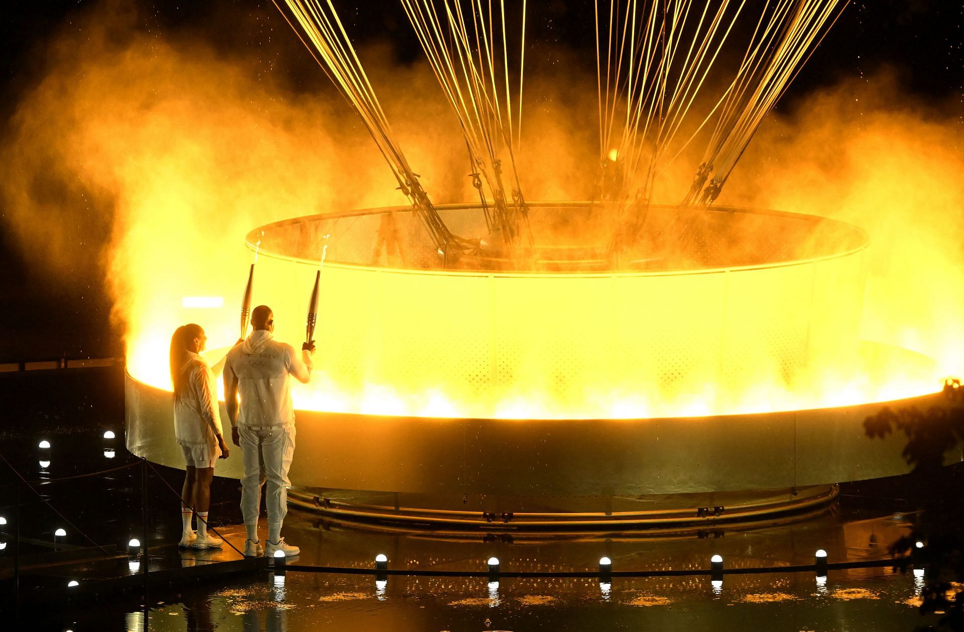 Teddy Riner (R) and Marie-Jose Perec light up the Olympic cauldron in Paris - Getty Images