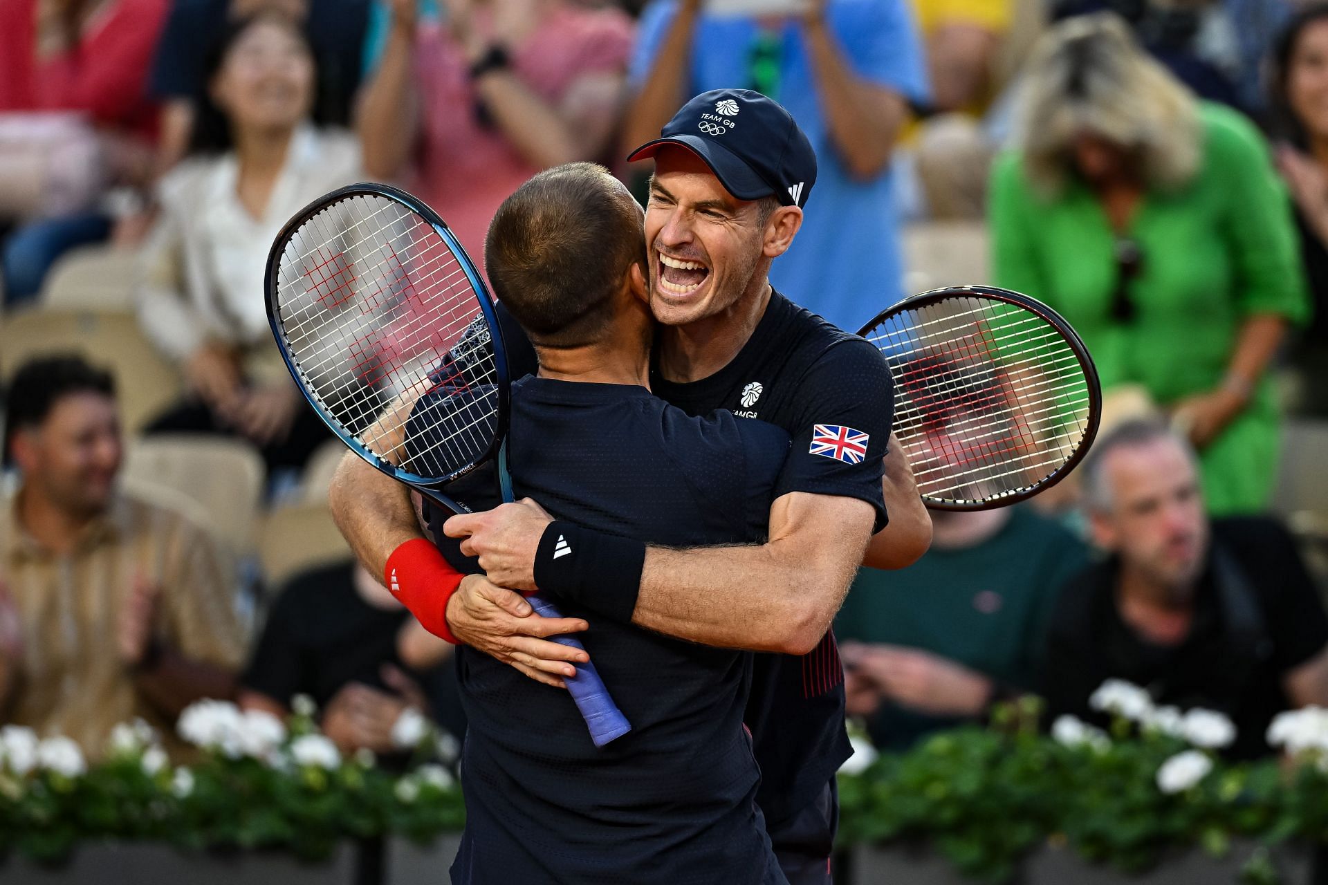 Andy Murray(facing the camera) embraces Dan Evans(back to the camera) after their first round win at the 2024 Paris Olympics