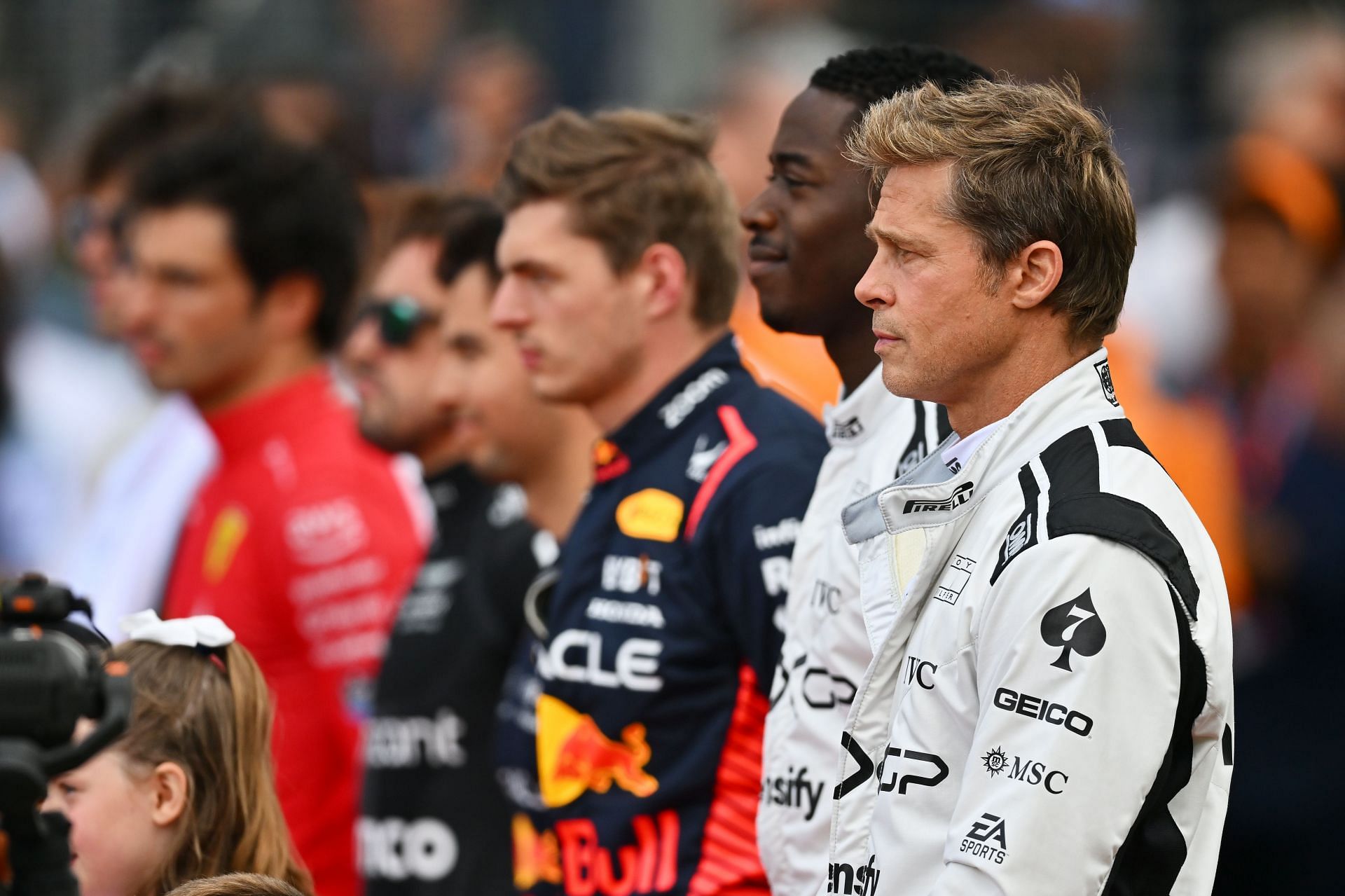 Brad Pitt and Damson Idris standing beside F1 drivers for the national anthem ahead of the 2023 British Grand Prix