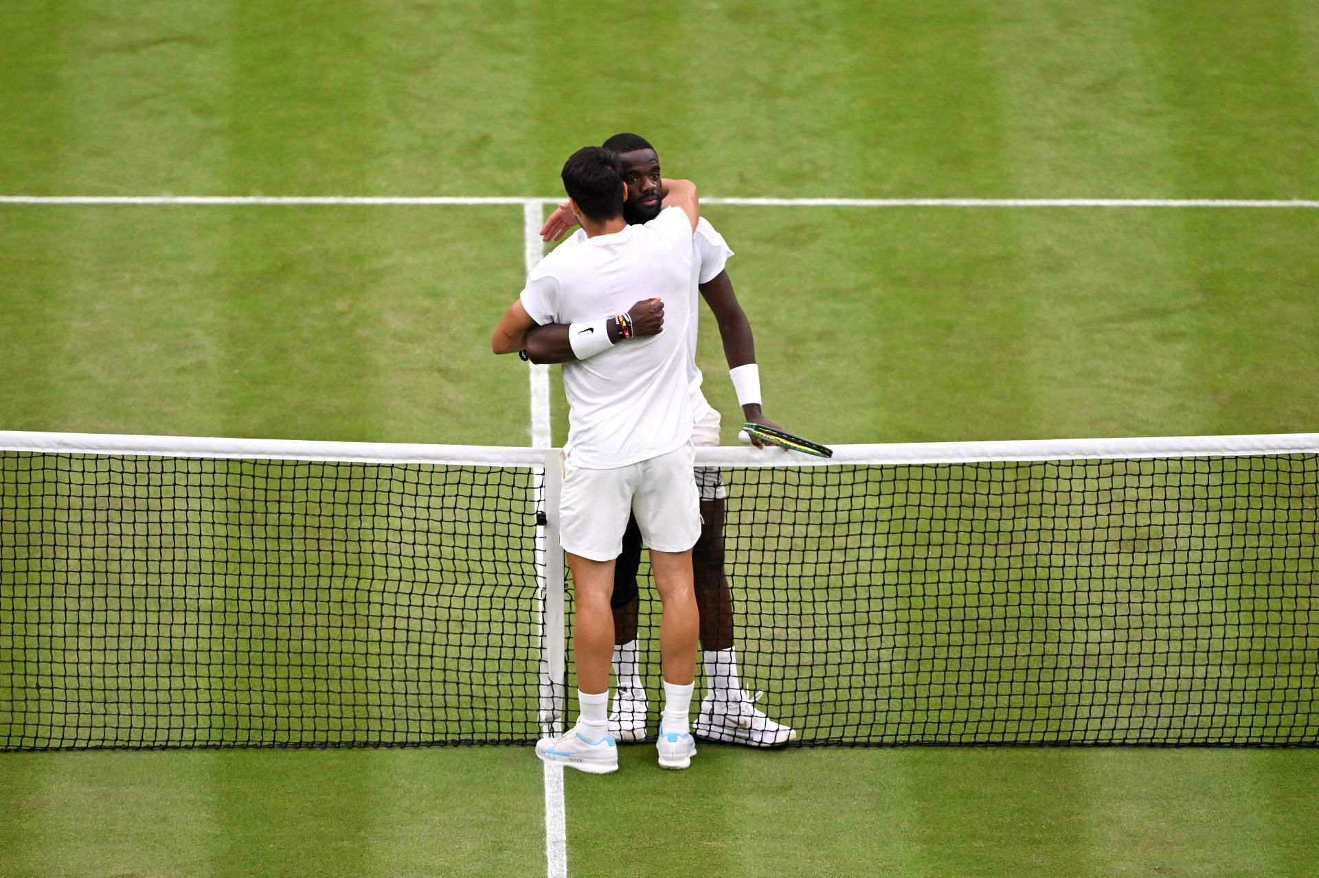 Carlos Alcaraz and Frances Tiafoe hugging each other after their third-round match at the 2024 Wimbledon Championships