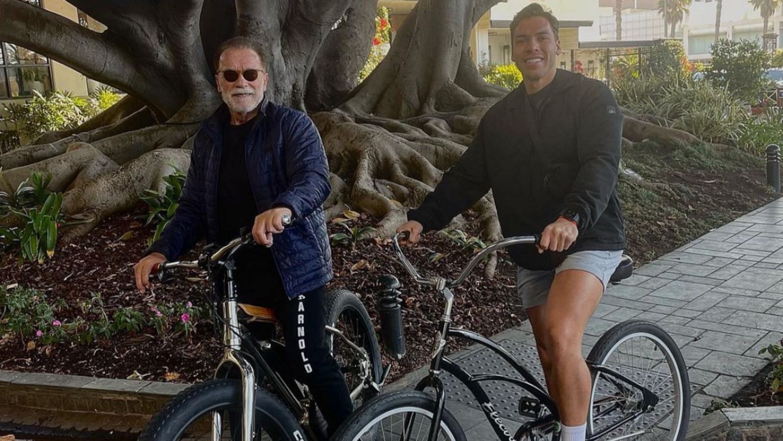 Arnold Schwarzenegger and Joseph Baena cycling together