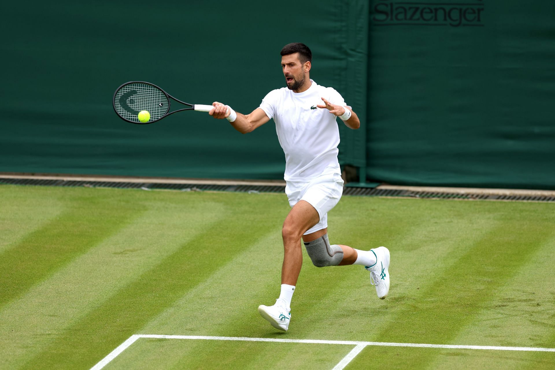 Novak Djokovic practicing at Wimbledon wearing a knee brace