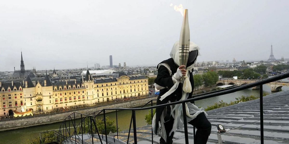 An unknown torch bearer was visible during the Paris Olympics opening ceremony (Source: Getty)