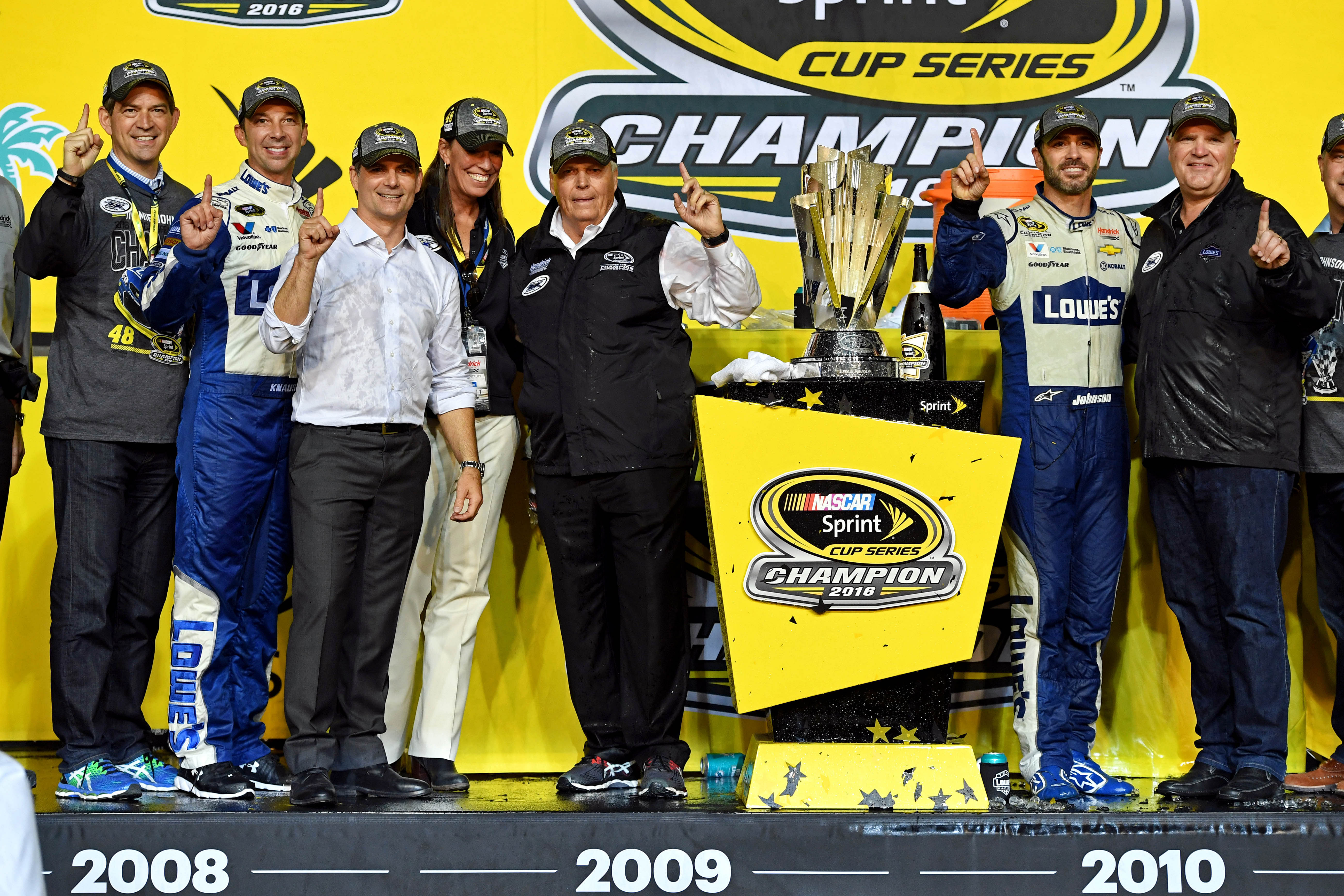 NASCAR Sprint Cup Series driver Jimmie Johnson (48) pose with the championship trophy with crew chief Chad Knaus, former driver Jeff Gordon and team owner Rick Henrick during the Ford Ecoboost 400 at Homestead-Miami Speedway. (Credit: Imagn)