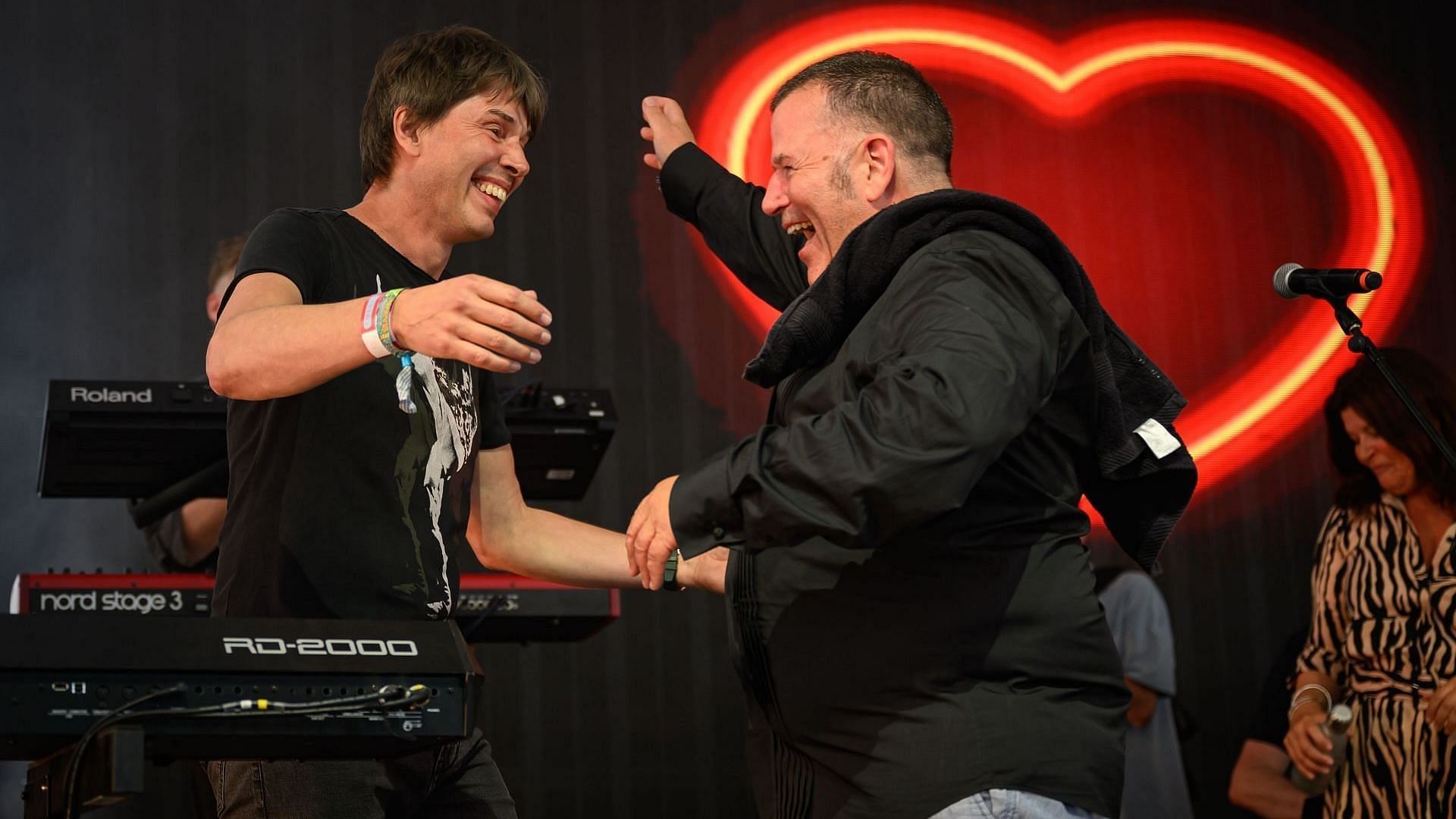 English physicist and television presenter Brian Cox (L) is greeted by singer Peter Cunnah as he makes a surprise appearance with D:REAM, temporarily re-taking his role as keyboard player, at the end of their set during day three of Glasto 2024 at Worthy Farm, Pilton on June 28, 2024 (Photo by Leon Neal/Getty Images)