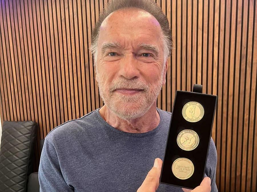 Arnold holding the Limited Bronze Medallions via arnoldspumpclub.com