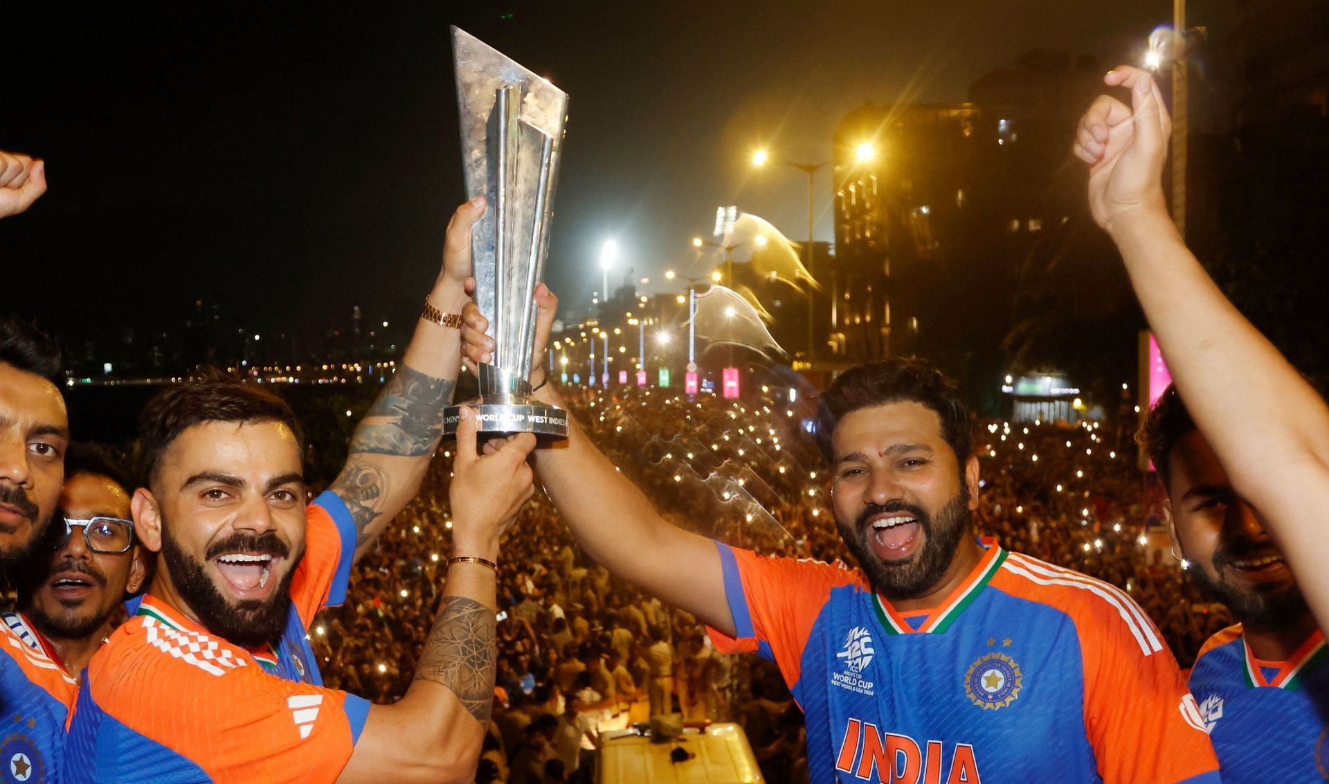 Virat Kohli lifting the WC trophy with Rohit Sharma during parade in Mumbai. (Image: BCCI/X)