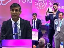 Beta Squad’s Niko Omilana pulls out an “L” sign as outgoing UK PM Rishi Sunak gives his farewell speech