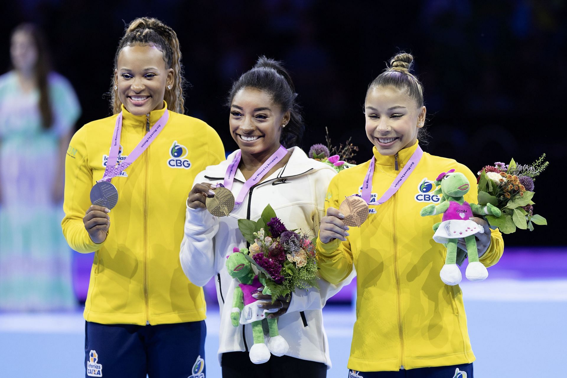 Rebeca Andrade [Left] alongside Simone Biles and teammate Flavia Saraiva on the podium at the Artistic Gymnastics World Championships. Antwerp 2023 [Image Source: Getty]