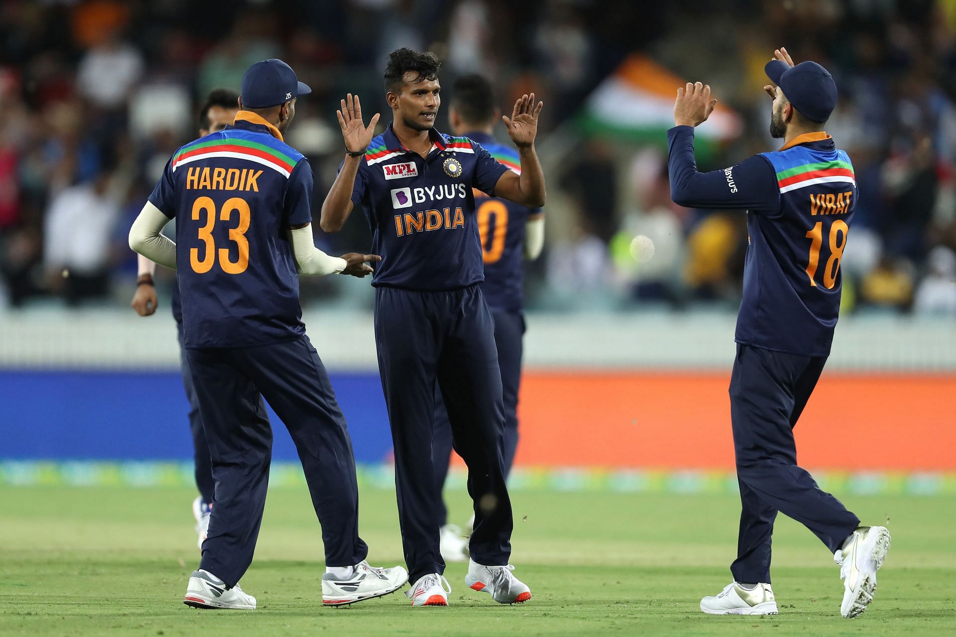 Natarajan celebrates with Indian teammates after bagging a wicket against Austraia.