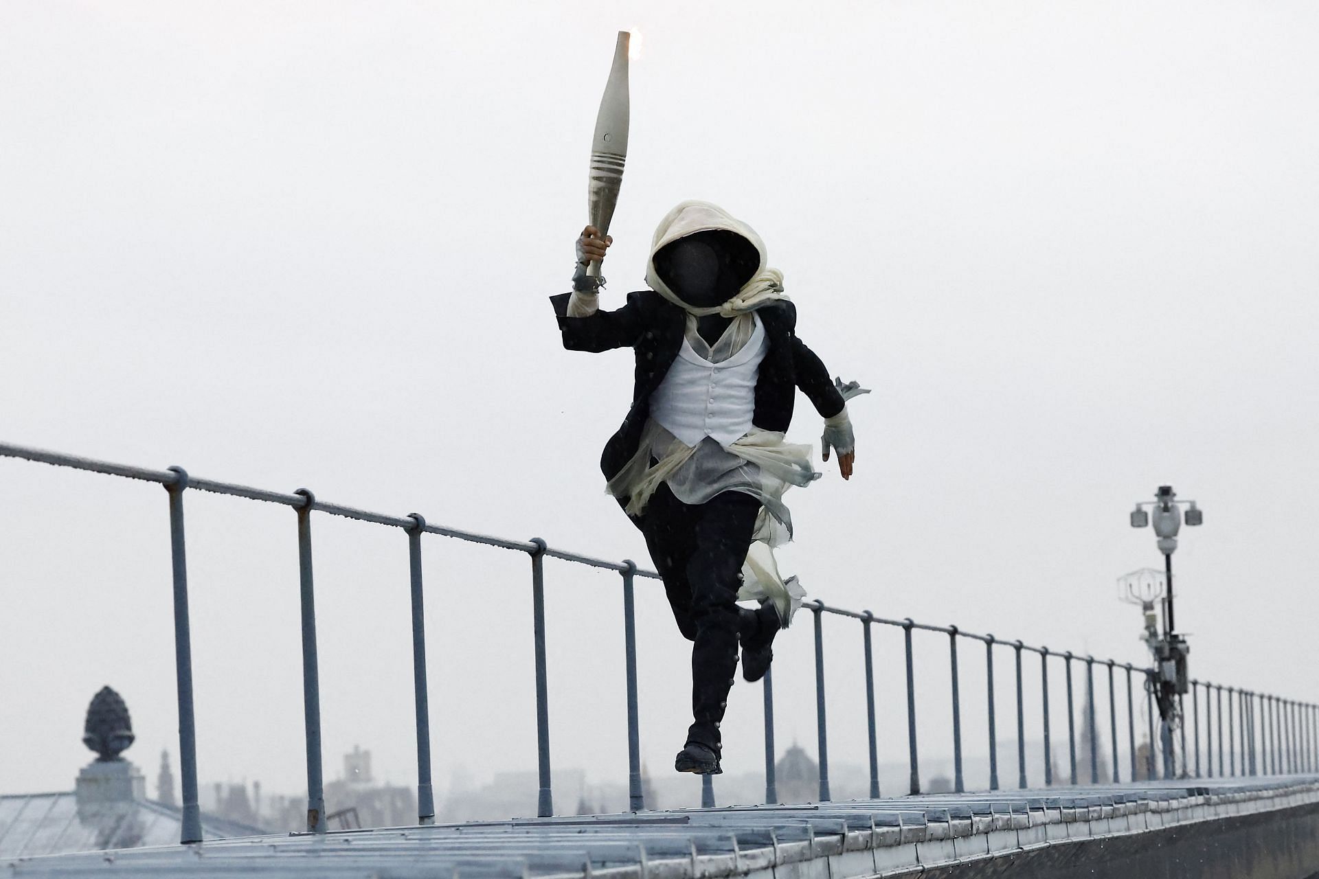 A torchbearer runs atop the Musee d'Orsay during the Opening Ceremony - Olympic Games Paris 2024: Day 0 - Source: Getty