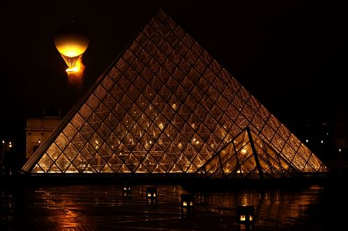 The Olympic Cauldron in the sky after being lit by the torch bearers with the Lourve in foreground during the opening ceremony.