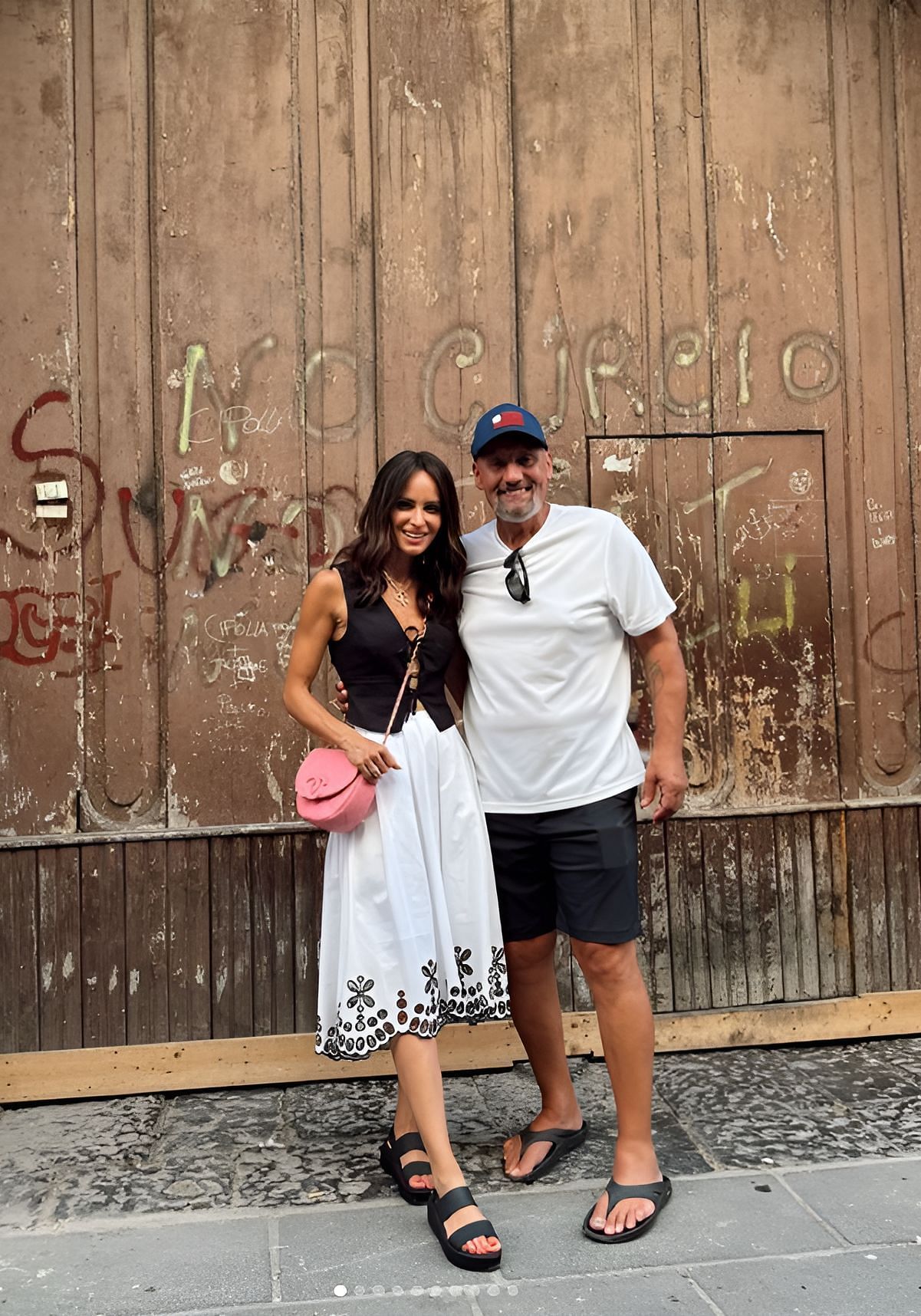 Samantha in a black top and white Poplin Eyelet Skirt by Moulinette Soeurs with floral embroidery, Brooklyn Low Wedge Crocs, and Chanel handbag, along with Kyle Busch (IMAGE: Instagram, Samantha Busch)