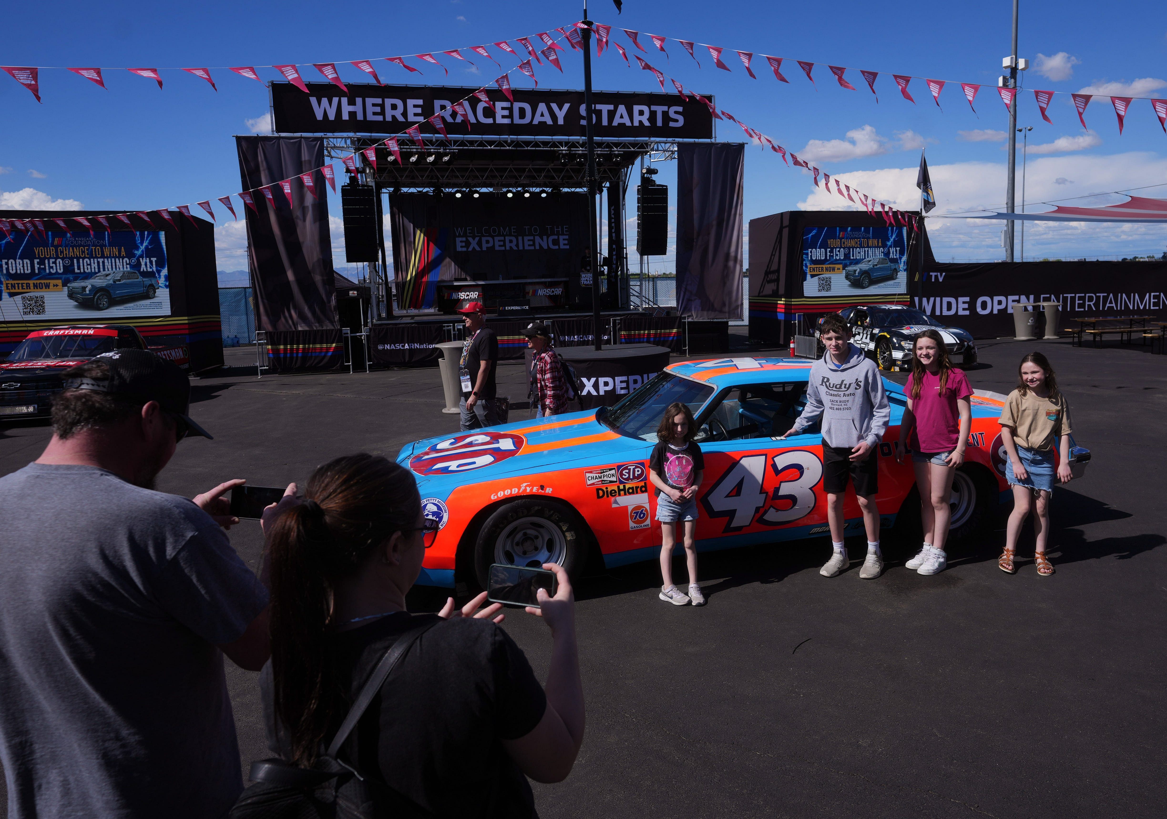 Race fans take a photo with Richard Petty's car at Phoenix Raceway on March 8, 2024, in Avondale, Arizona. (Source: Imagn)