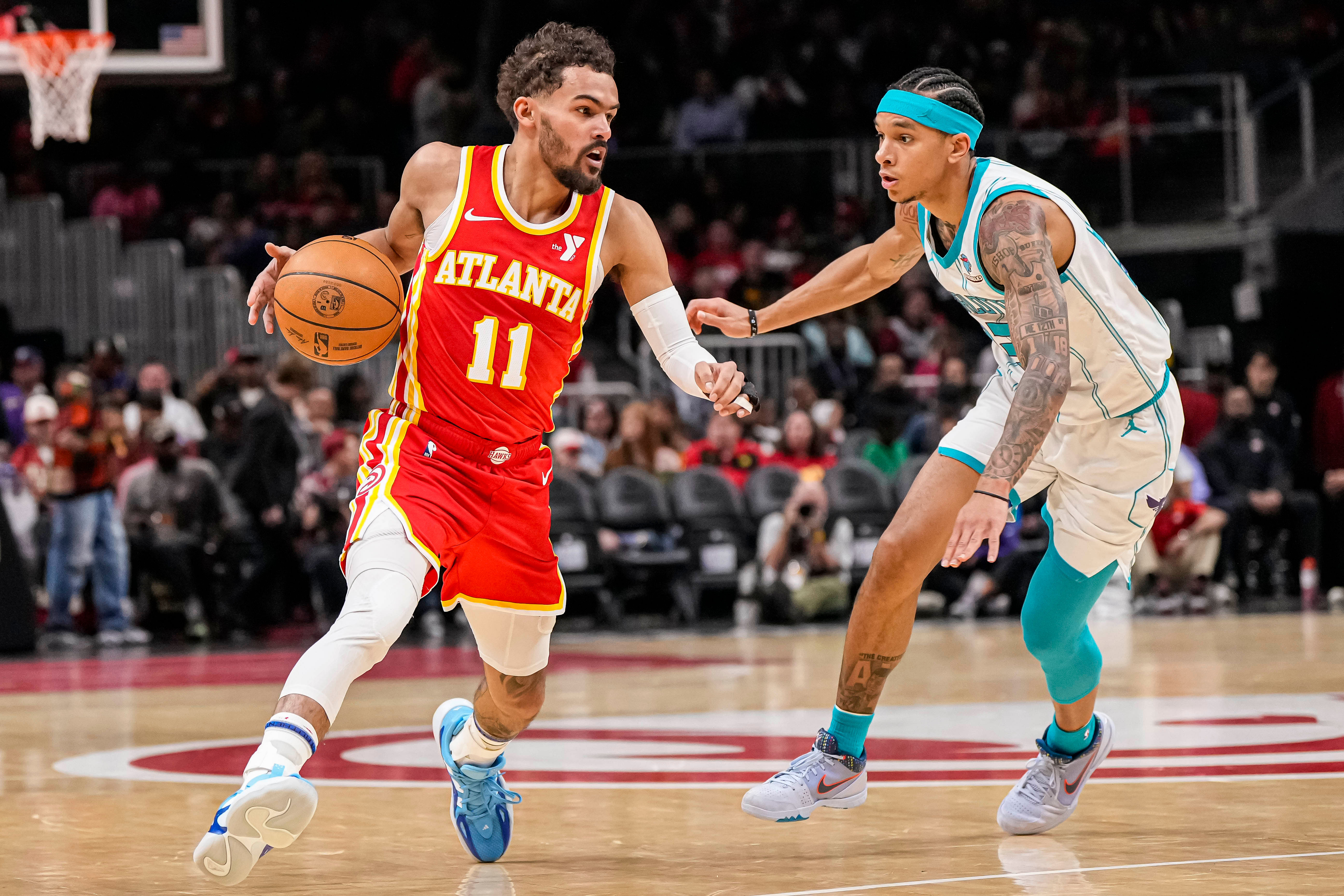 Atlanta Hawks guard Trae Young dribbles past Charlotte Hornets guard Tre Mann at State Farm Arena. Photo Credit: Imagn