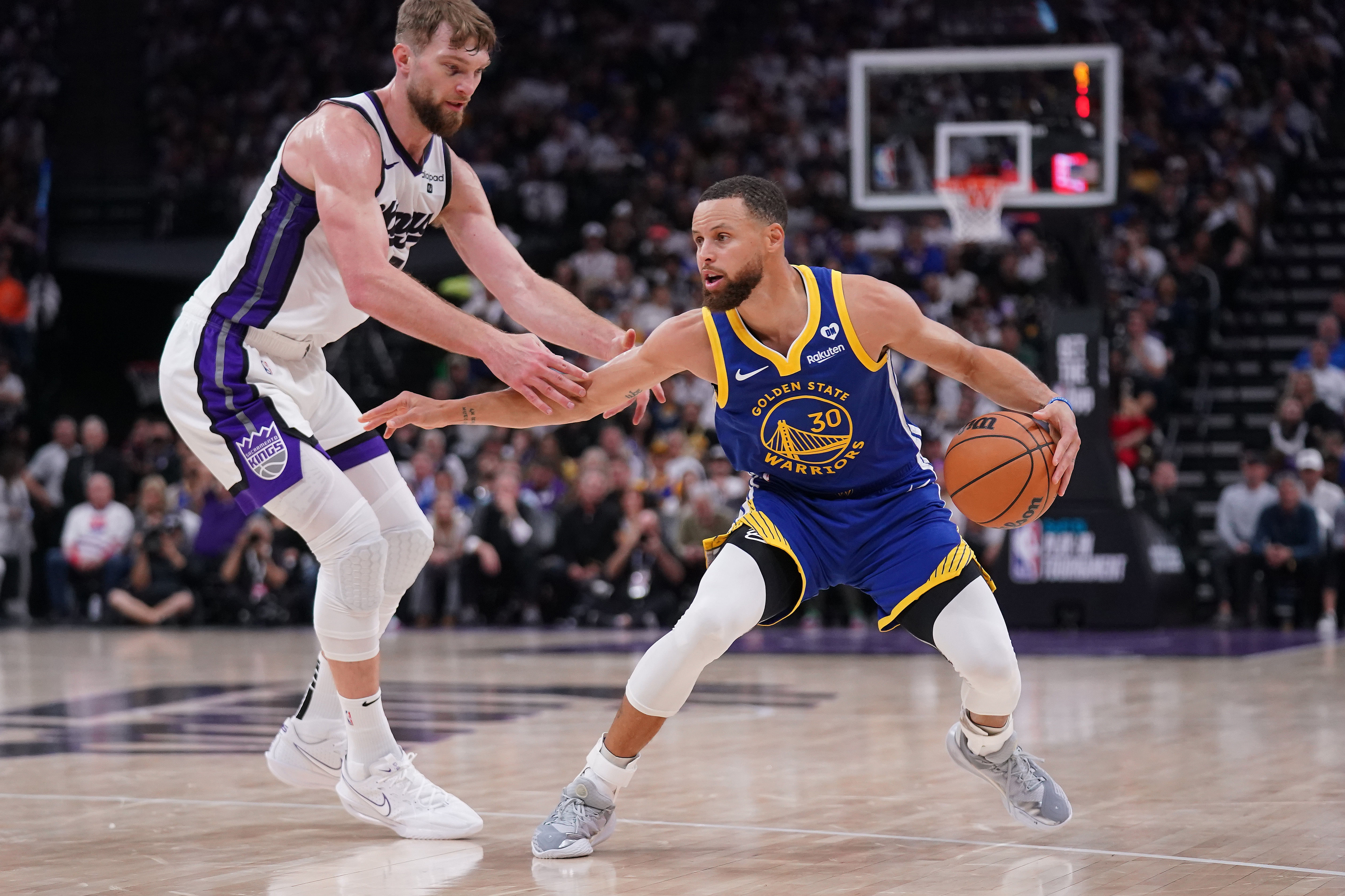 Golden State Warriors guard Stephen Curry dribbles the ball next to Sacramento Kings forward Domantas Sabonis at the Golden 1 Center. Photo Credit: Imagn