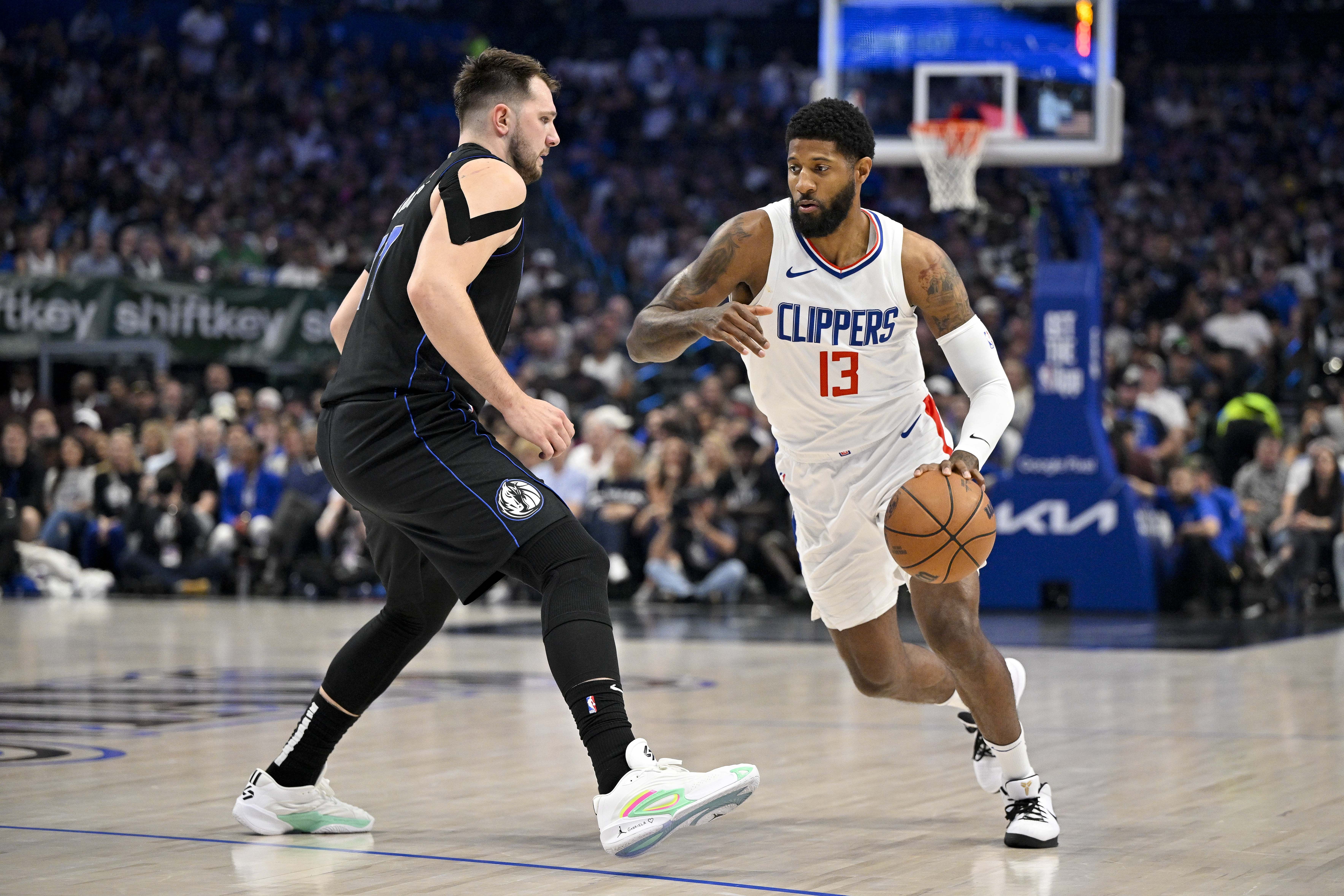 Clippers forward Paul George moves the ball past Dallas Mavericks guard Luka Doncic at American Airlines Center. Photo Credit: Imagn