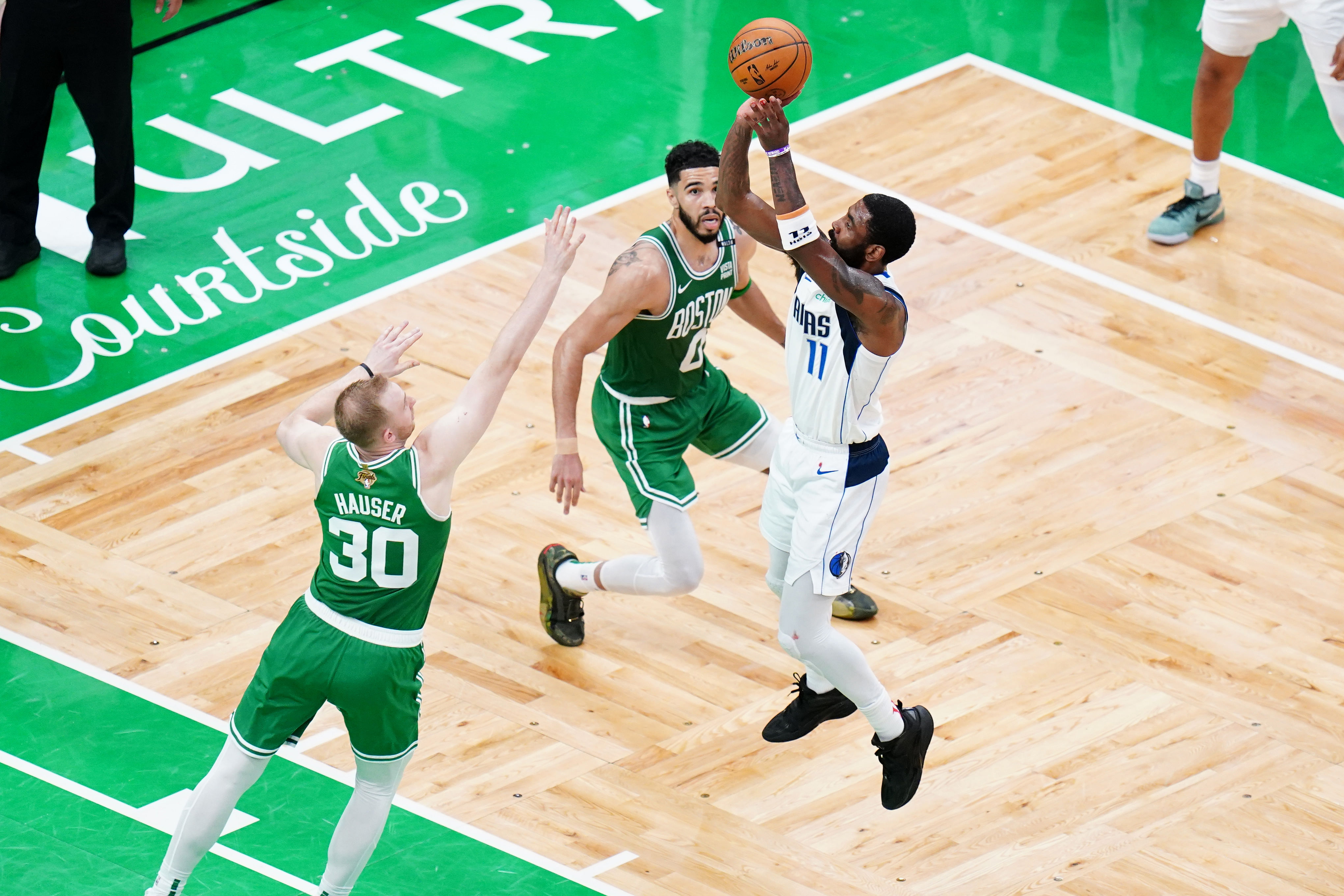 Dallas Mavericks guard Kyrie Irving shoots over Boston Celtics forward Sam Hauser (Imagn)