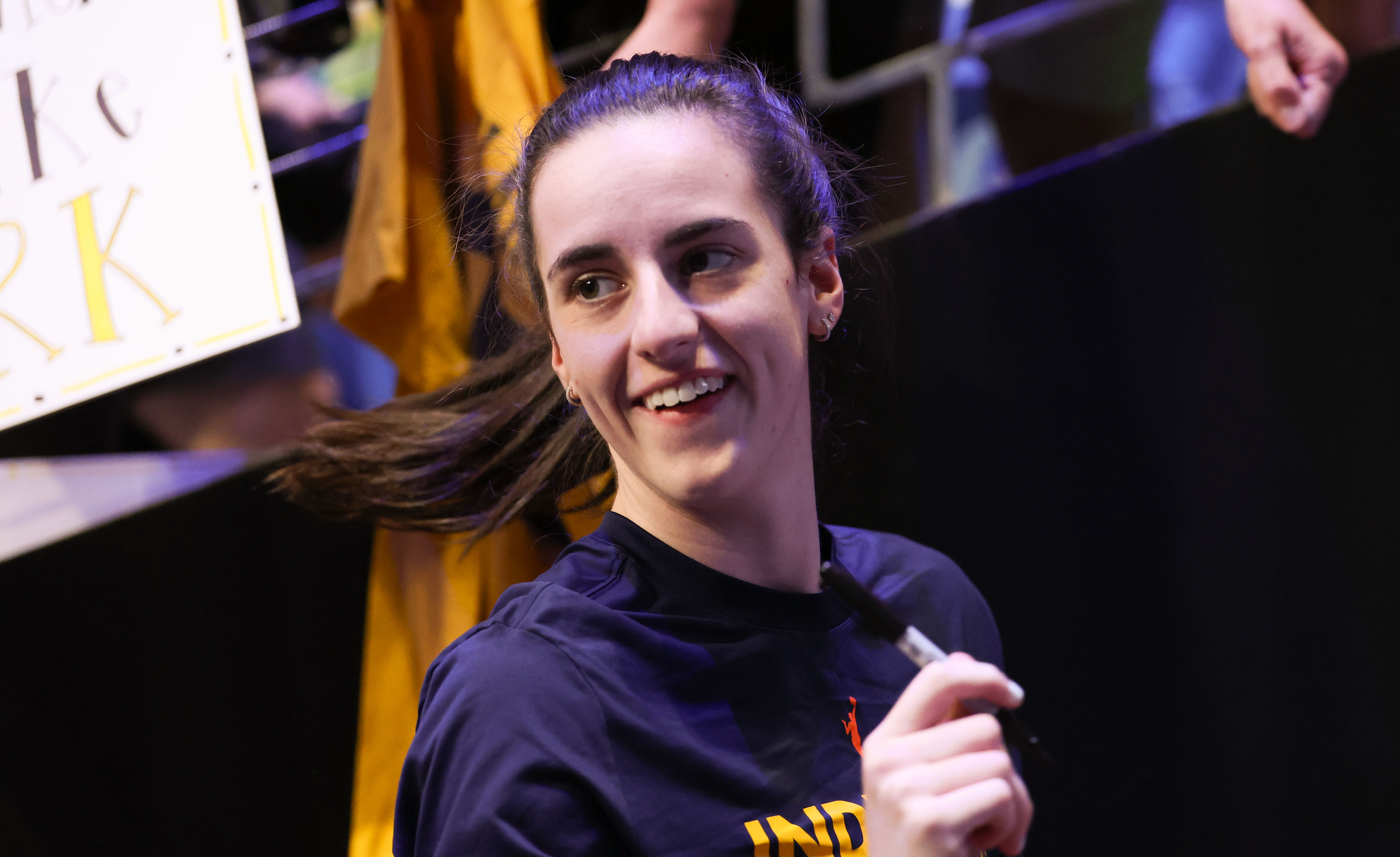 Indiana Fever guard Caitlin Clark reacts to signing autographs before the game against the Dallas Wings at College Park Center. Photo Credit: Imagn