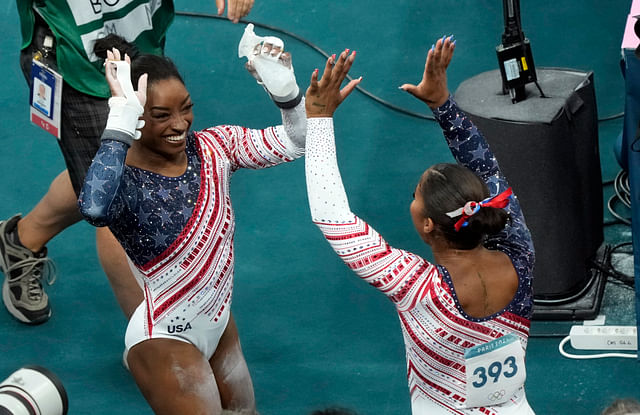 Jul 30, 2024; Paris, France; Simone Biles of the United States high fives Jordan Chiles after competing on the uneven bars during the women&rsquo;s team final at the Paris 2024 Olympic Summer Games at Bercy Arena. Mandatory Credit: Jack Gruber-USA TODAY Sports - Source: Imagn