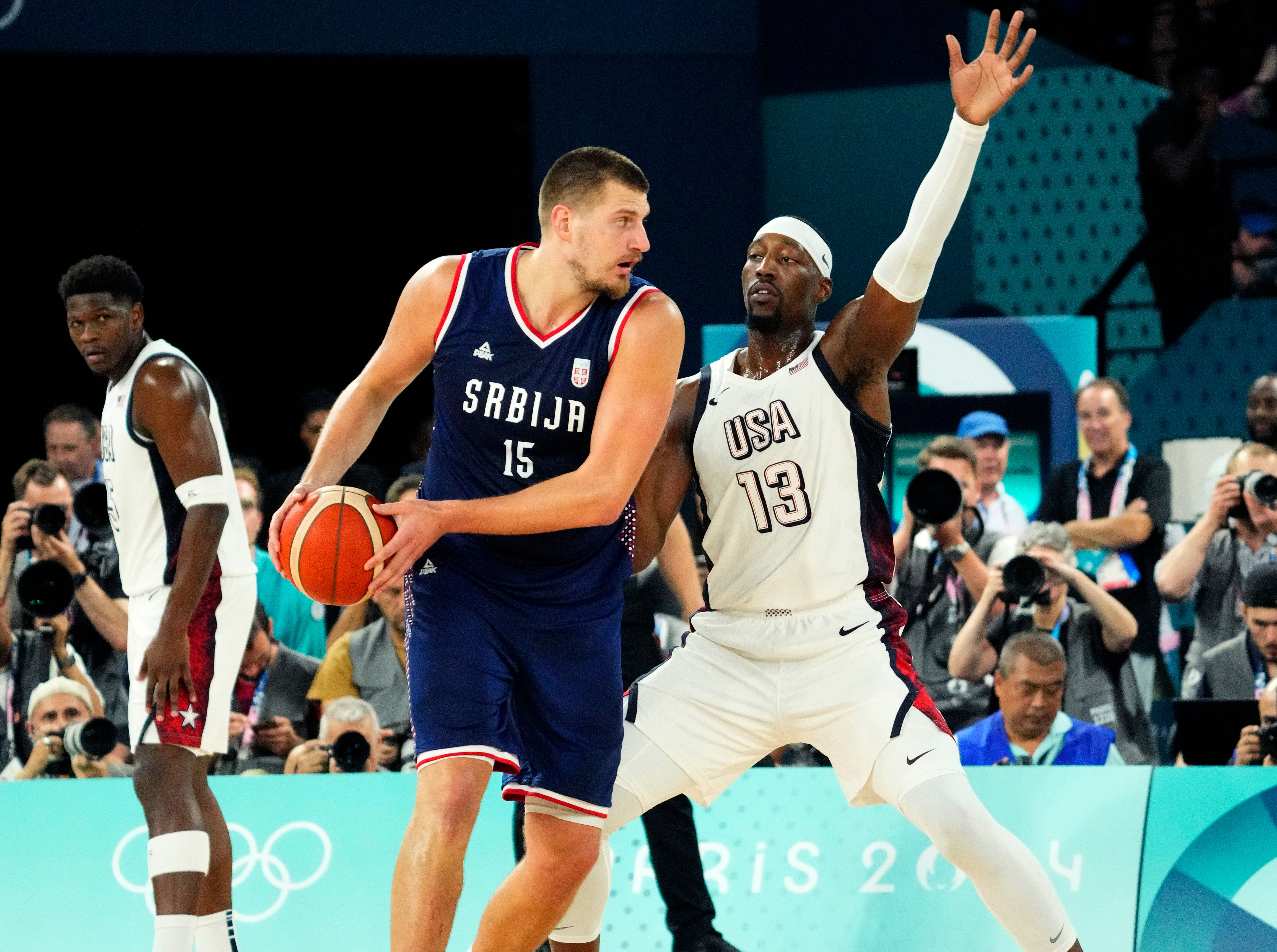 Nikola Jokic controls the ball while defended by Bam Adebayo at the Olympics men&#039;s basketball event. Photo Credit: IMAGN