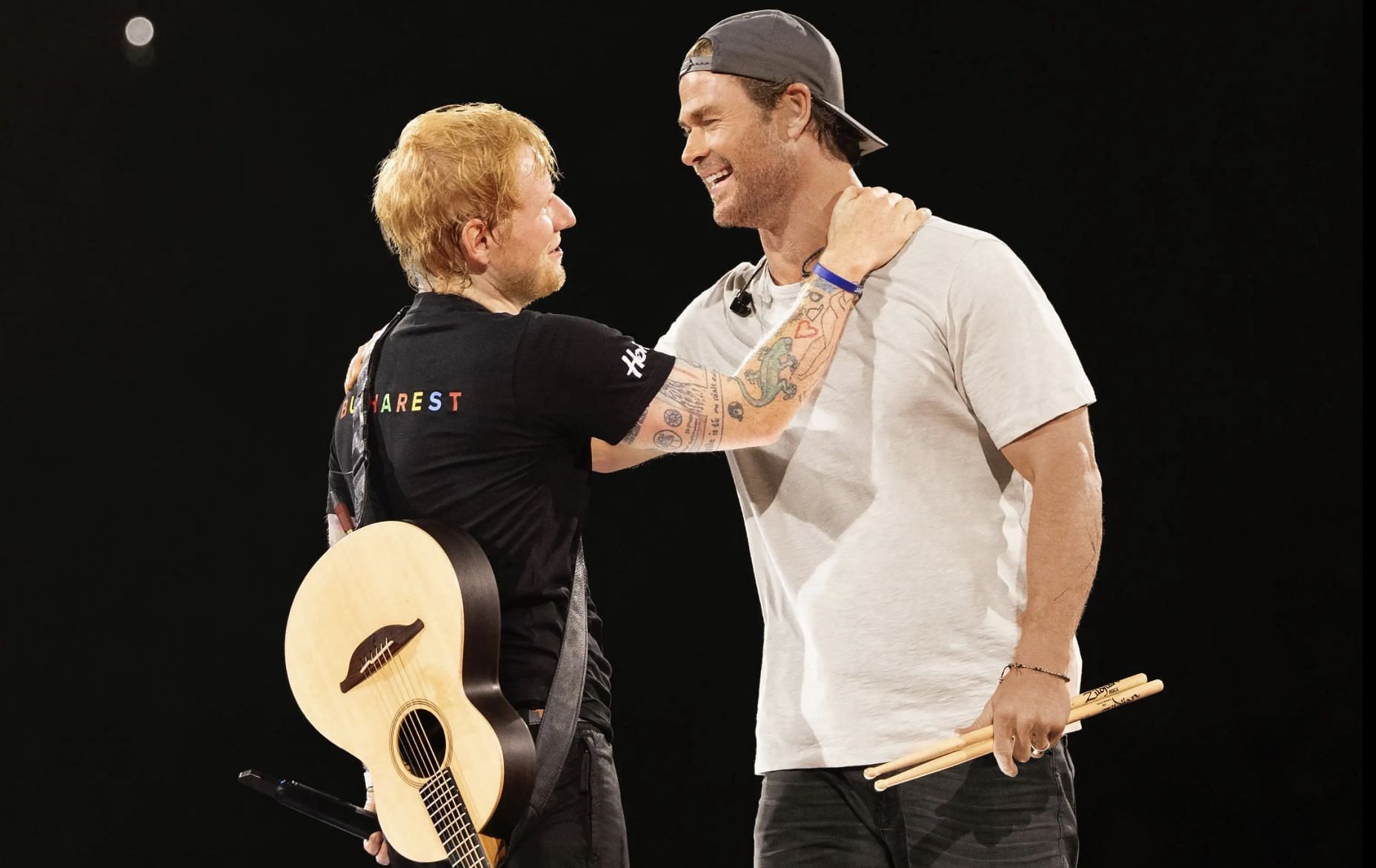 Chris Hemsworth surprises fans by joining Ed Sheeran on stage, showcasing his drumming skills at the Romania concert. (Image via Instagram/@teddysphotos)