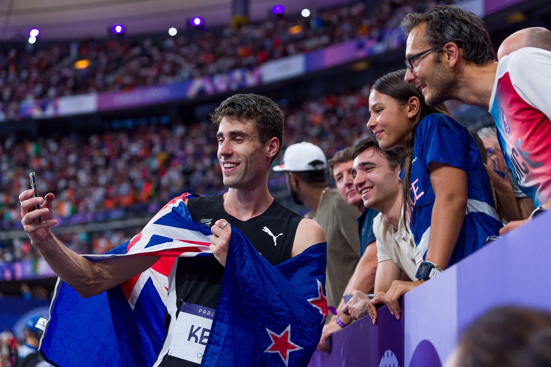 Hamish Kerr takes selfies with fans after the finals of the Men&#039;s High Jump at the Paris Olympics 2024 [Image Source: Getty]