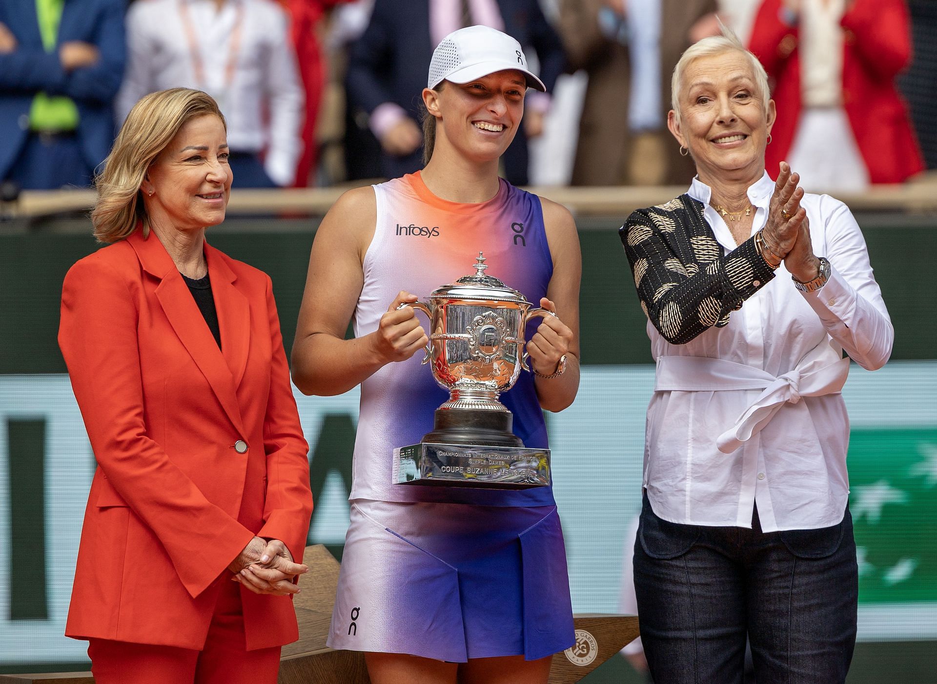 Martina Navratilova and Chris Evert present the winner&#039;s trophy to Iga Świątek. (Image: Getty)