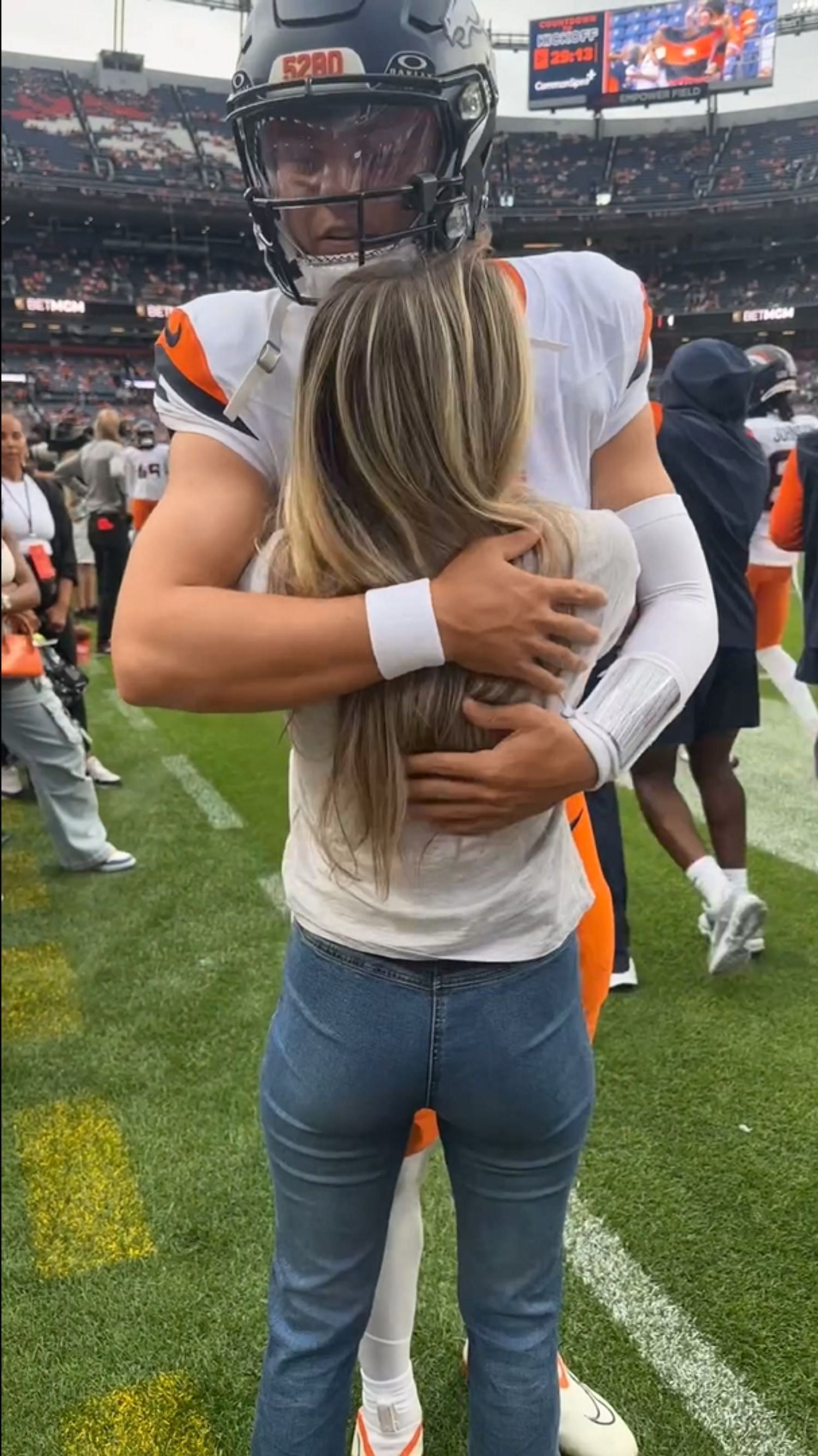 Zach Wilson greets his fiancee Nicolette Dellanno after his Broncos' lopsided defeat of the Cardinals