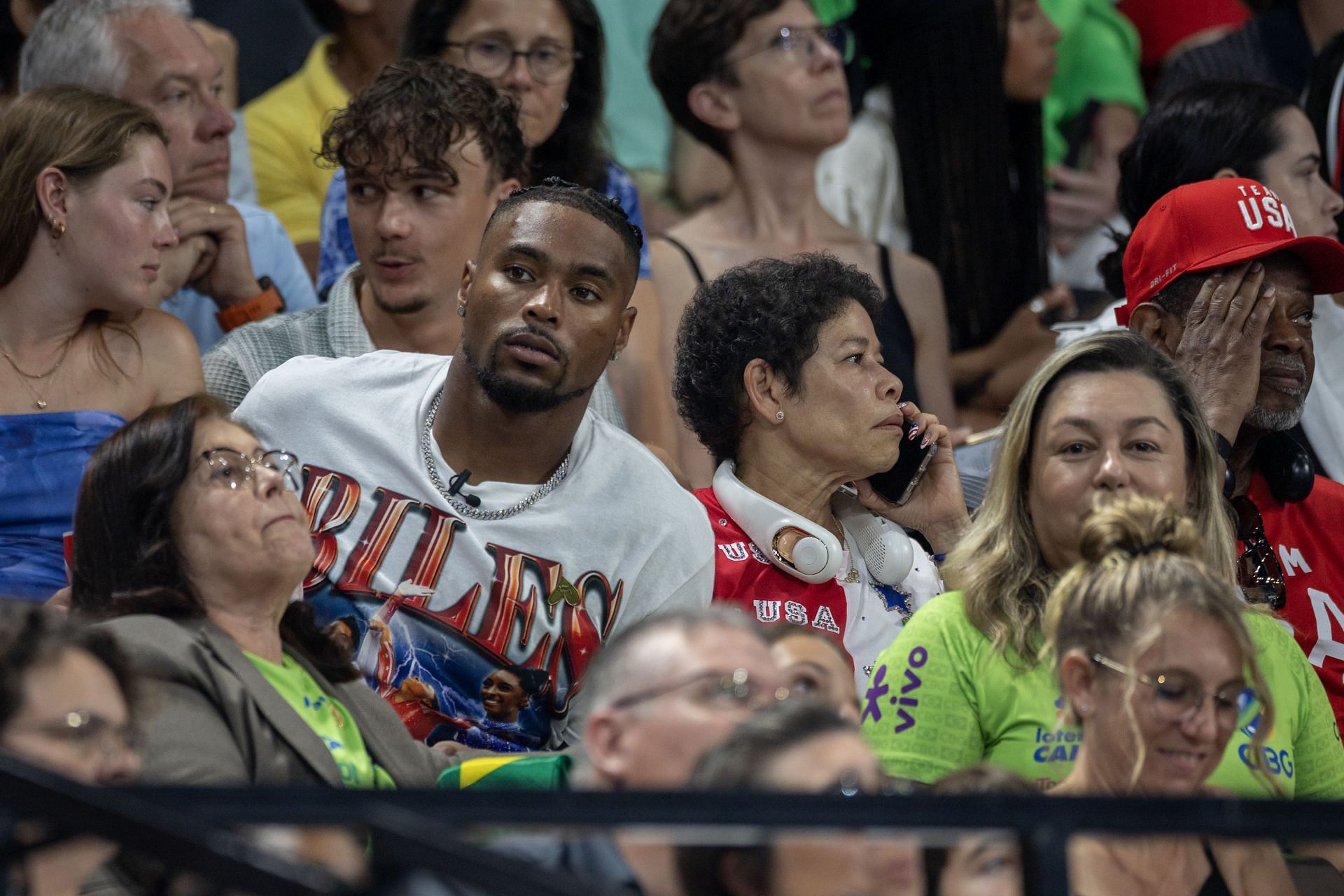 Jonathan Owens [in white T Shirt] watching the Team All Around Finals of Artistic Gymnastics at Paris Olympics 2024 along with Simone Biles&#039; adoptive parents [Image Source: Getty]