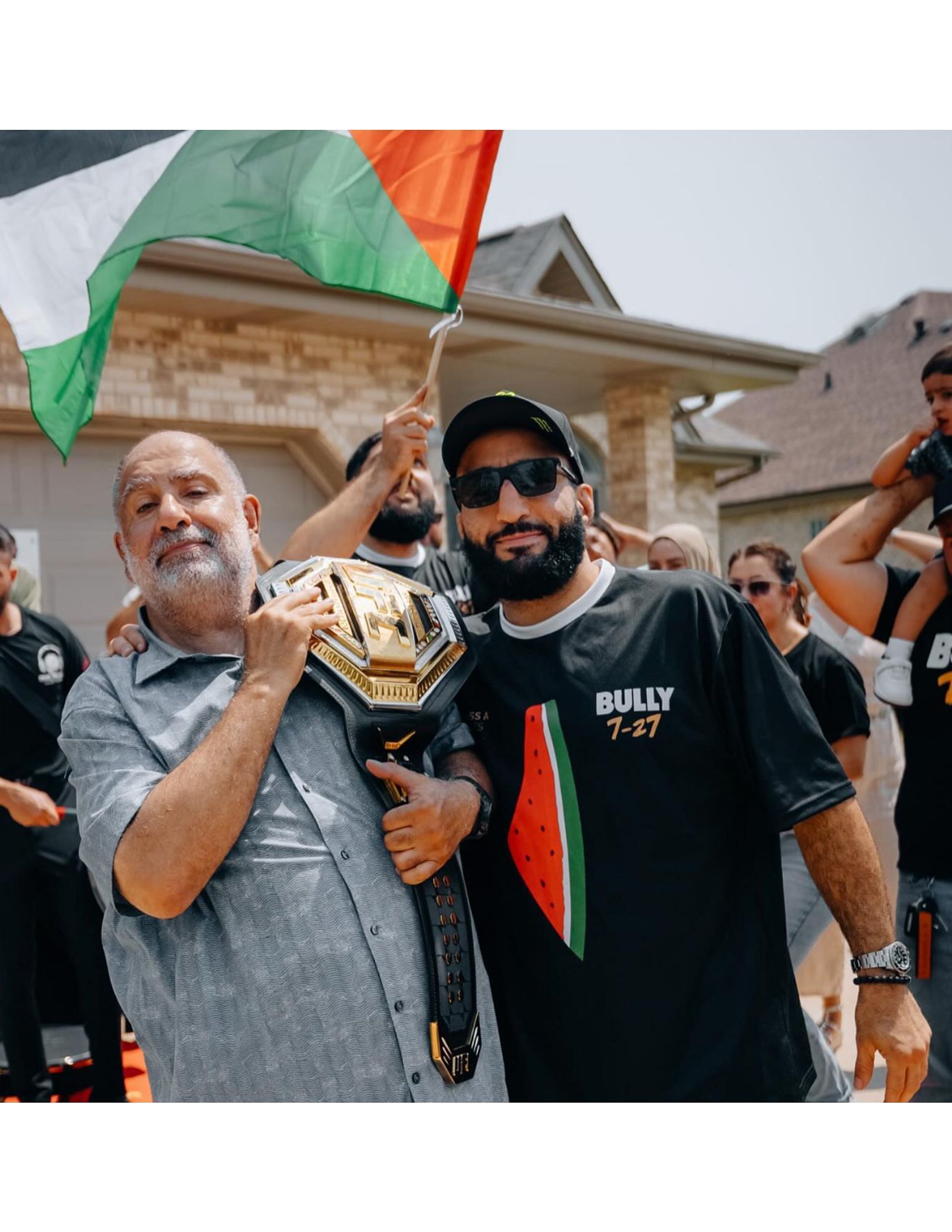 Belal Muhammad's father (left) holding his son's (right) championship belt. [Image courtesy: @bullyb170 on Instagram]