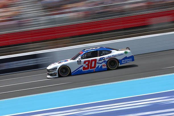 A NASCAR Xfinity Series Car in action on track.