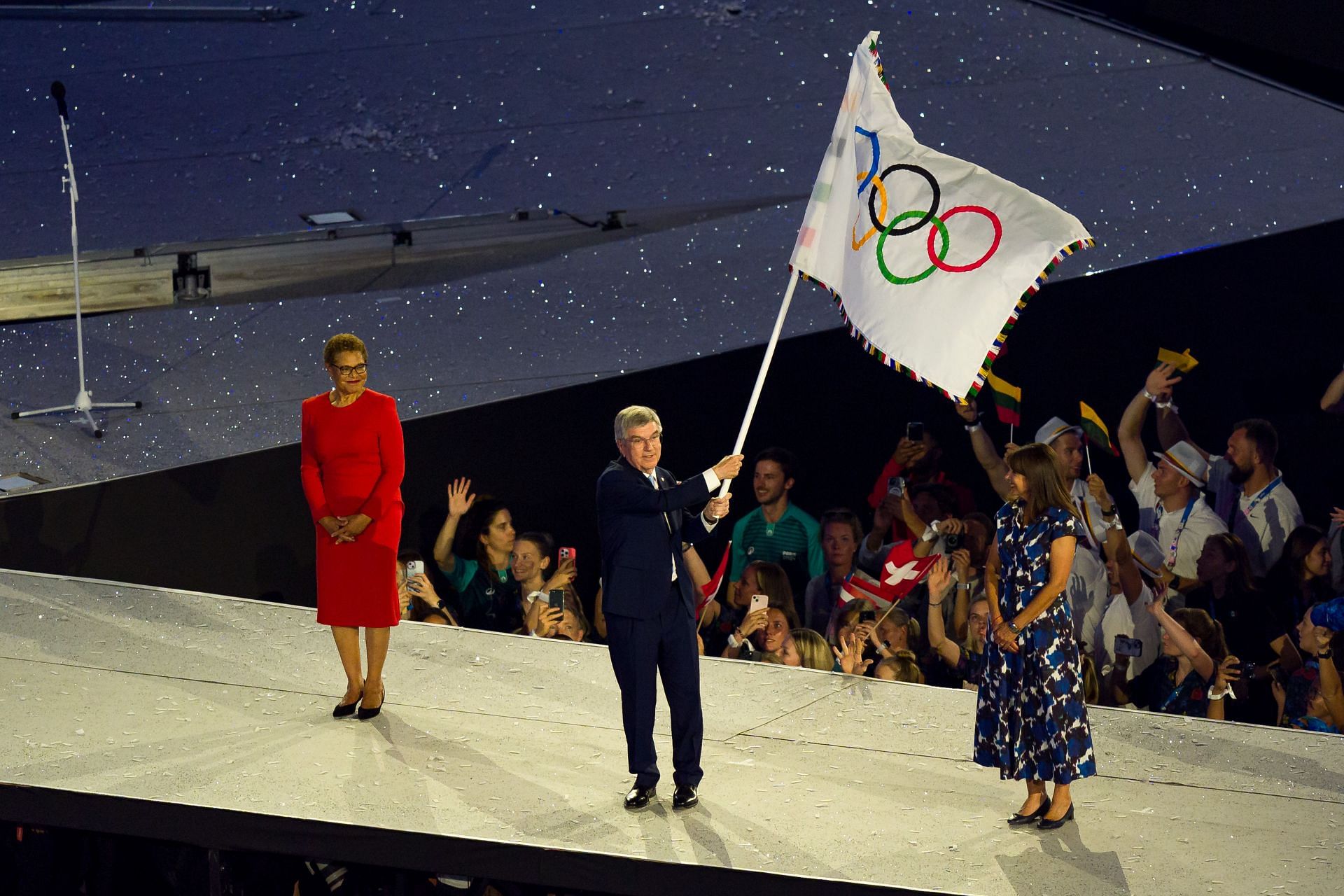 Outgoing IOC President Thomas Bach waves the Olympic flag at the closing ceremony of the Paris Olympics - Getty Images