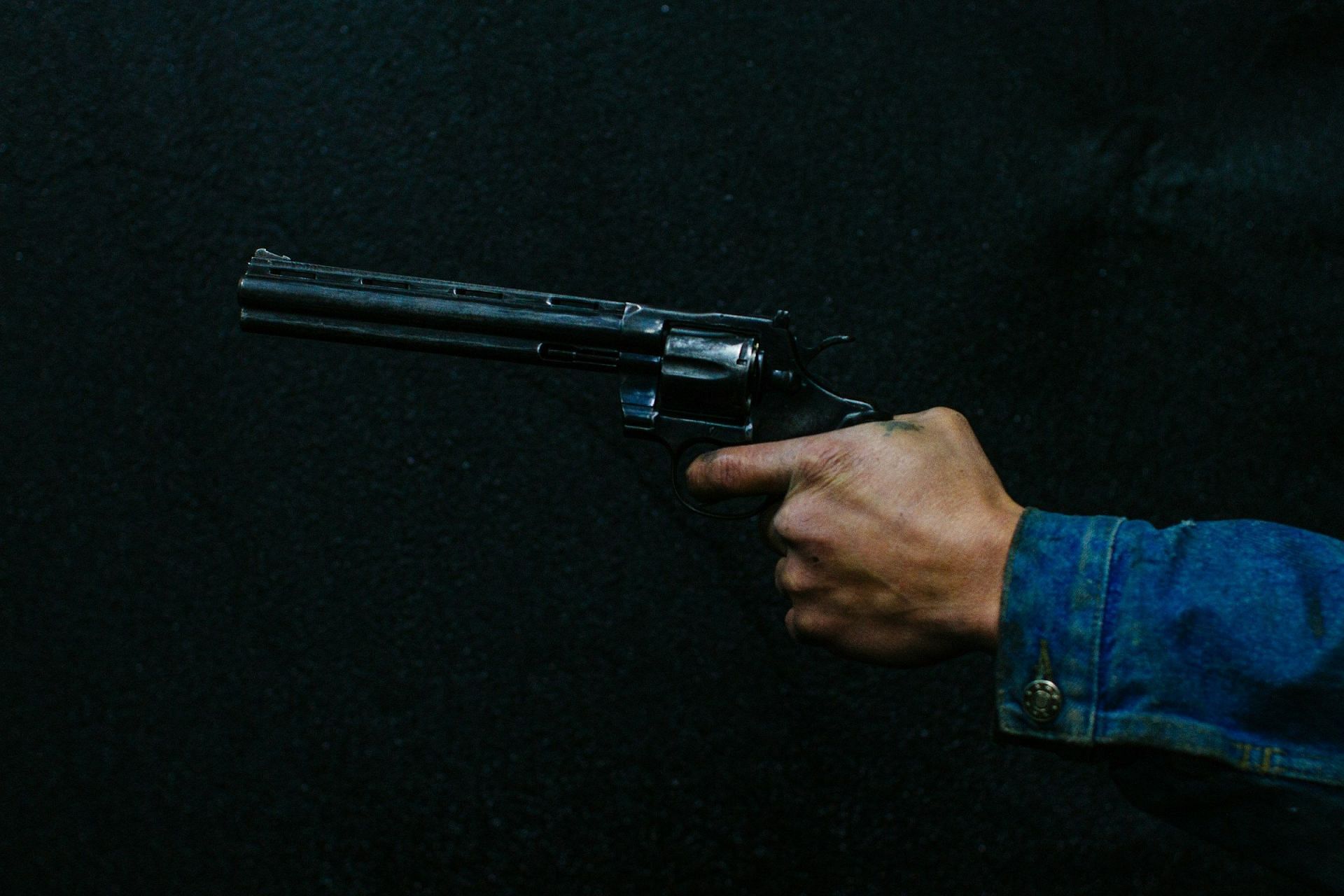 A representative image of a person holding a gun (Image via Unsplash/@@alejoreinoso)