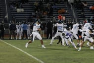 West Orange High (West Orange, NJ) Head Coach Darnell Grant (fifth from the left on the far sideline) watches his team play during a night game against rival East Orange Campus (East Orange, NJ). (Photo Credit: Kerry E Porter)