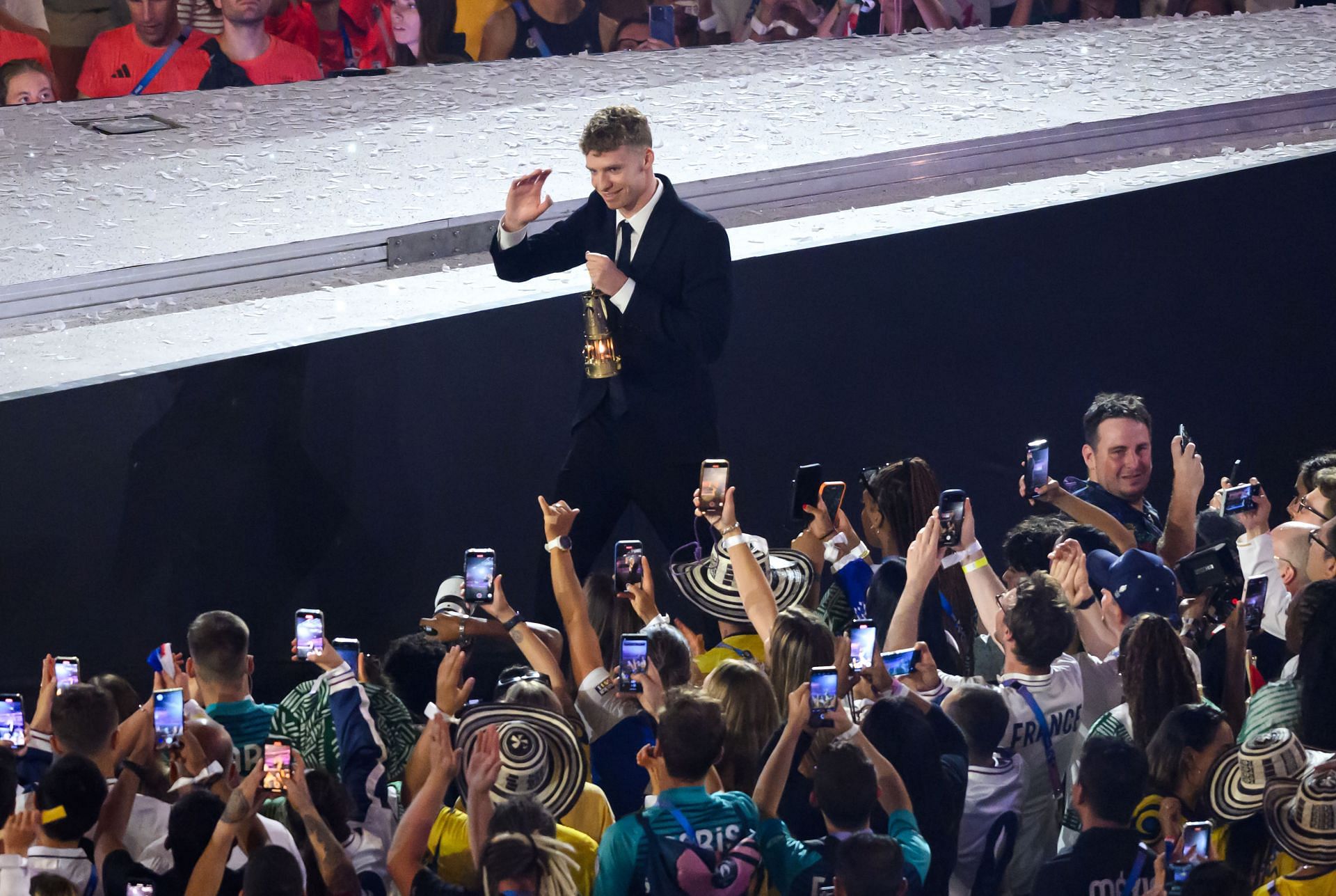 Leon Marchand carries the Olympic flame during the closing ceremony at the Paris Olympics - Getty Images