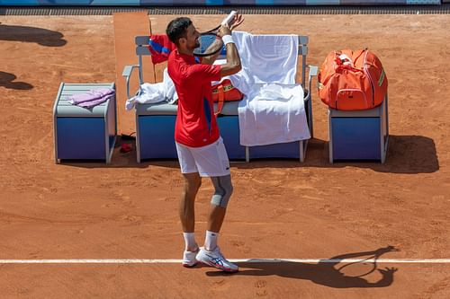 Novak Djokovic imitates playing a violin on his racquet at the Olympic Games Paris 2024. (Image: Getty)