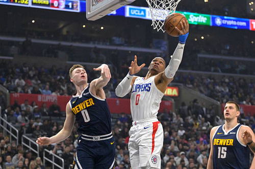 Former LA Clippers guard Russell Westbrook scoring over Nuggets guard Christian Braun - Source: Imagn