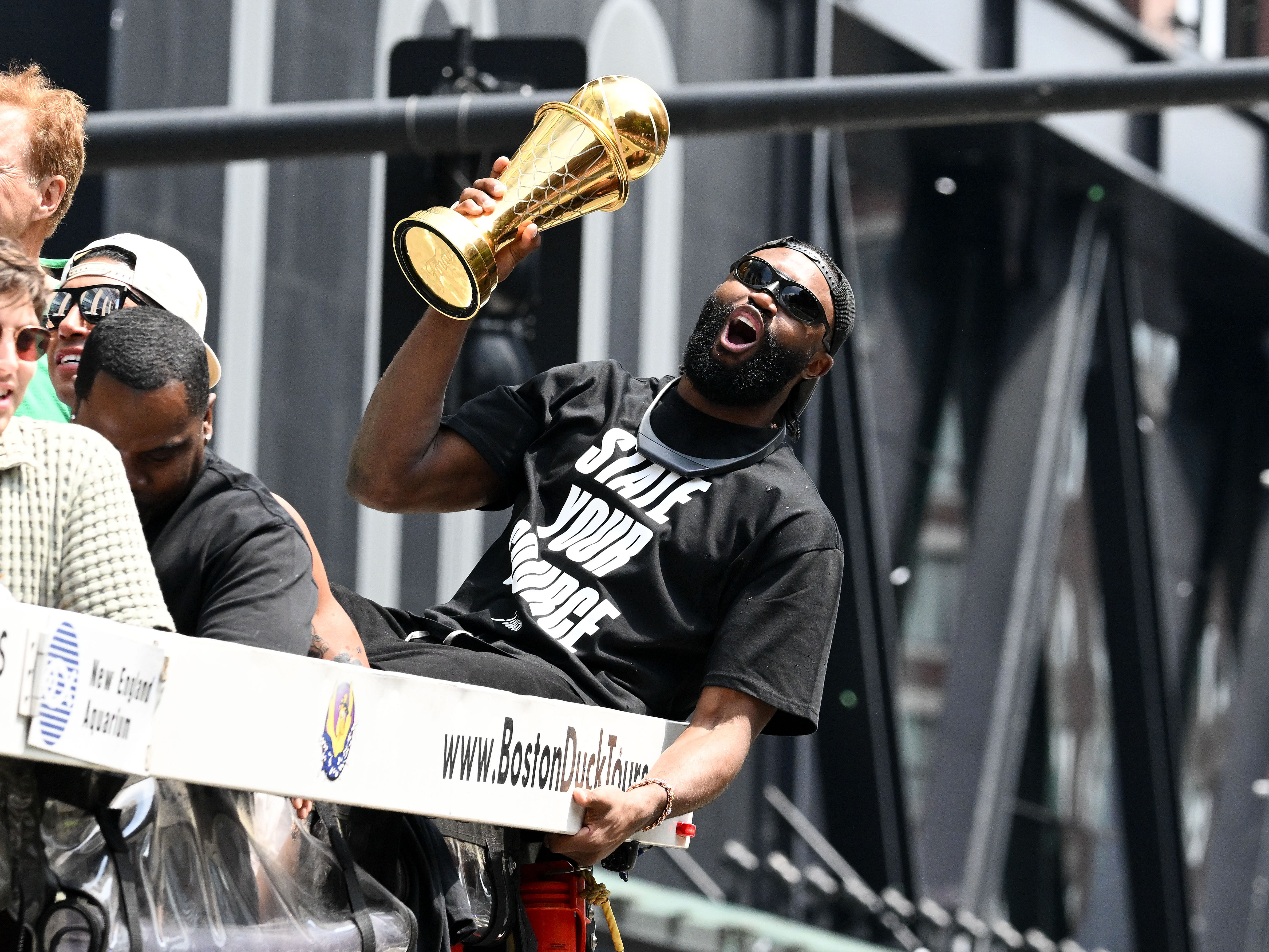 Boston Celtics guard Jaylen Brown holds the MVP trophy during the 2024 NBA Championship parade in Boston. Photo Credit: Imagn