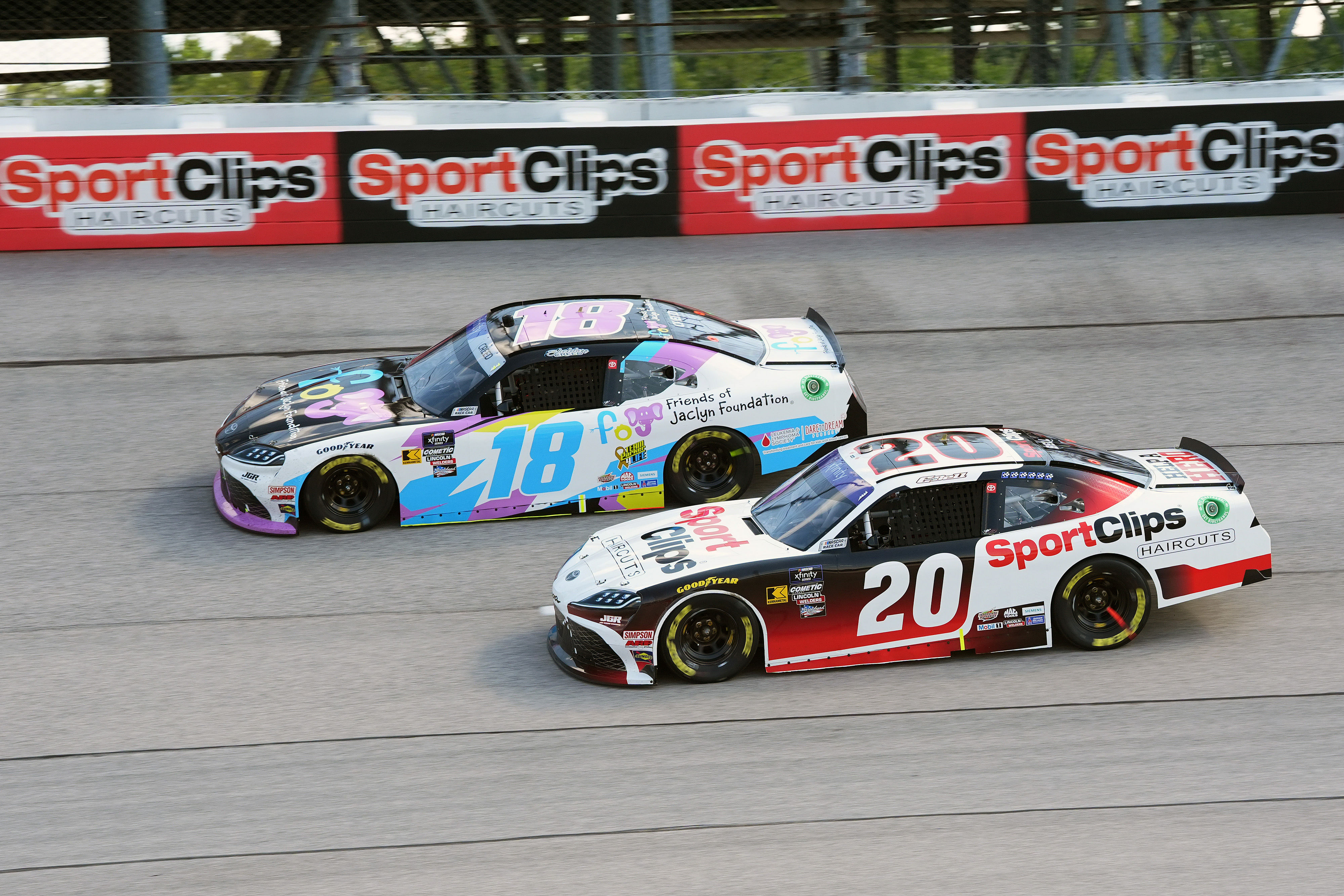 Sheldon Creed (18) races against teammate Christopher Bell (20) at the Sport Clips Haircuts VFW Help A Hero 200 (Source: Imagn)