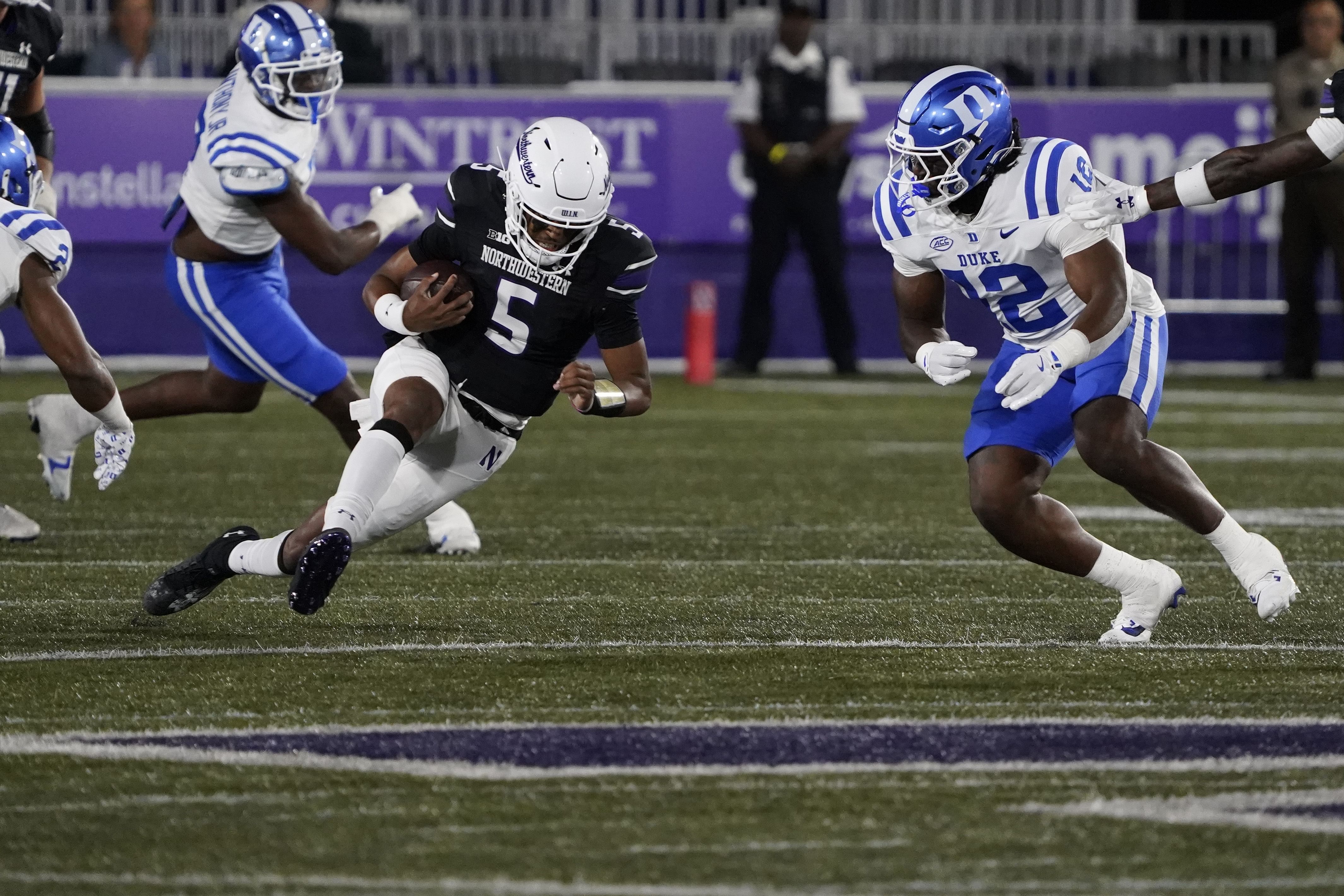 Duke Blue Devils linebacker Tre Freeman (12) tries to tackle Northwestern Wildcats quarterback Mike Wright (5) - Source: Imagn