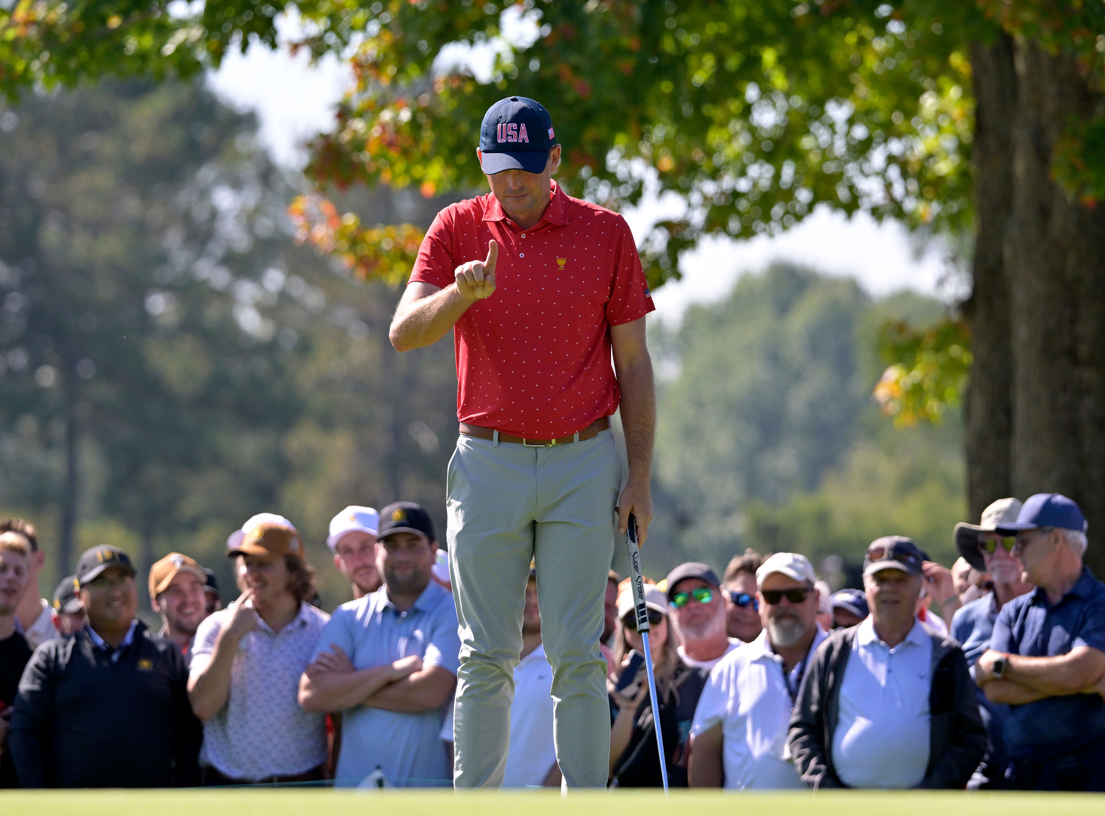 Keegan Bradley lines up his putt on the green of the first hole in a singles match during the final round of The Presidents Cup (Image Source: Imagn)