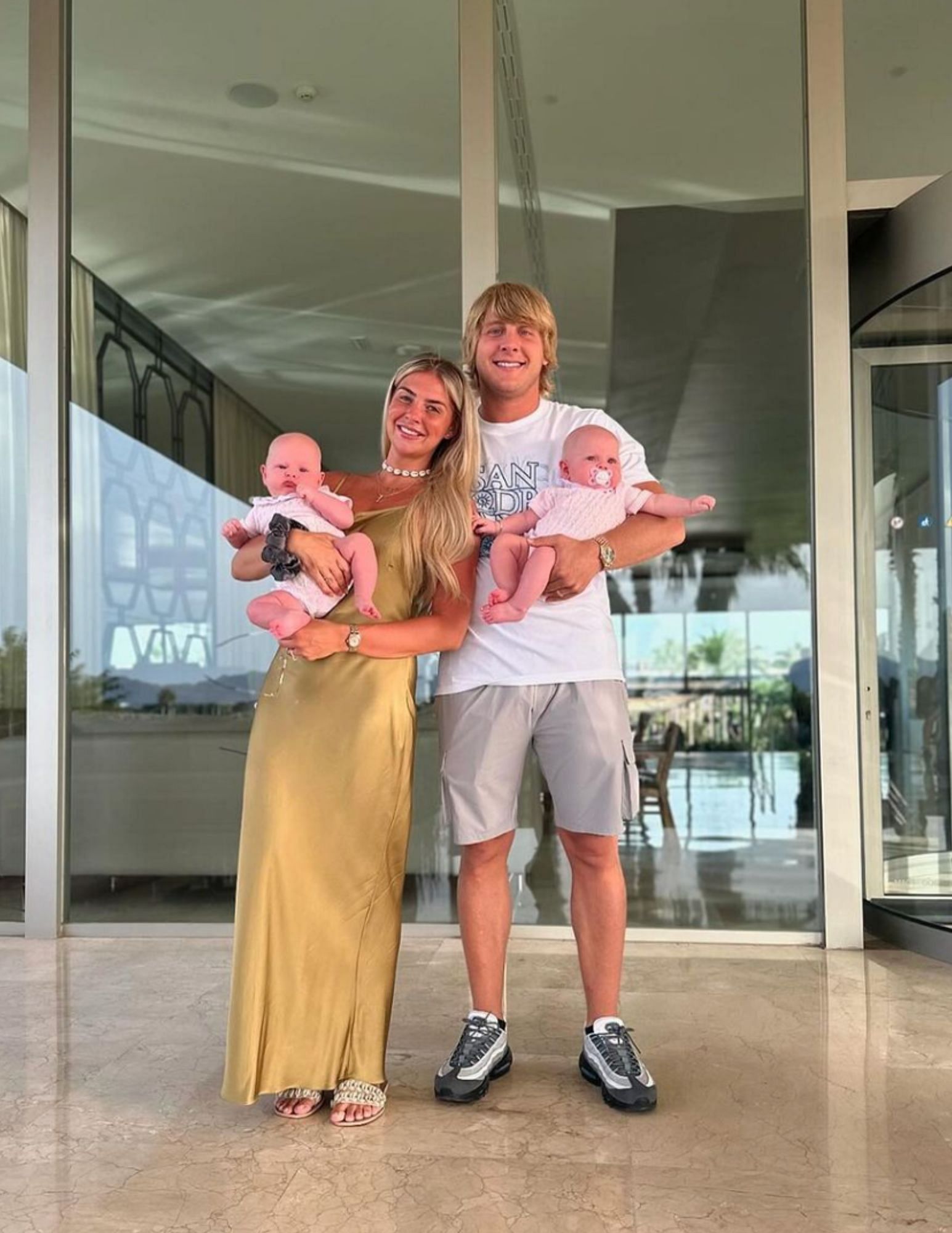 Paddy Pimblett (right) and his wife Laura (left) holding their two babies. [via @theufcbaddy on Instagram]