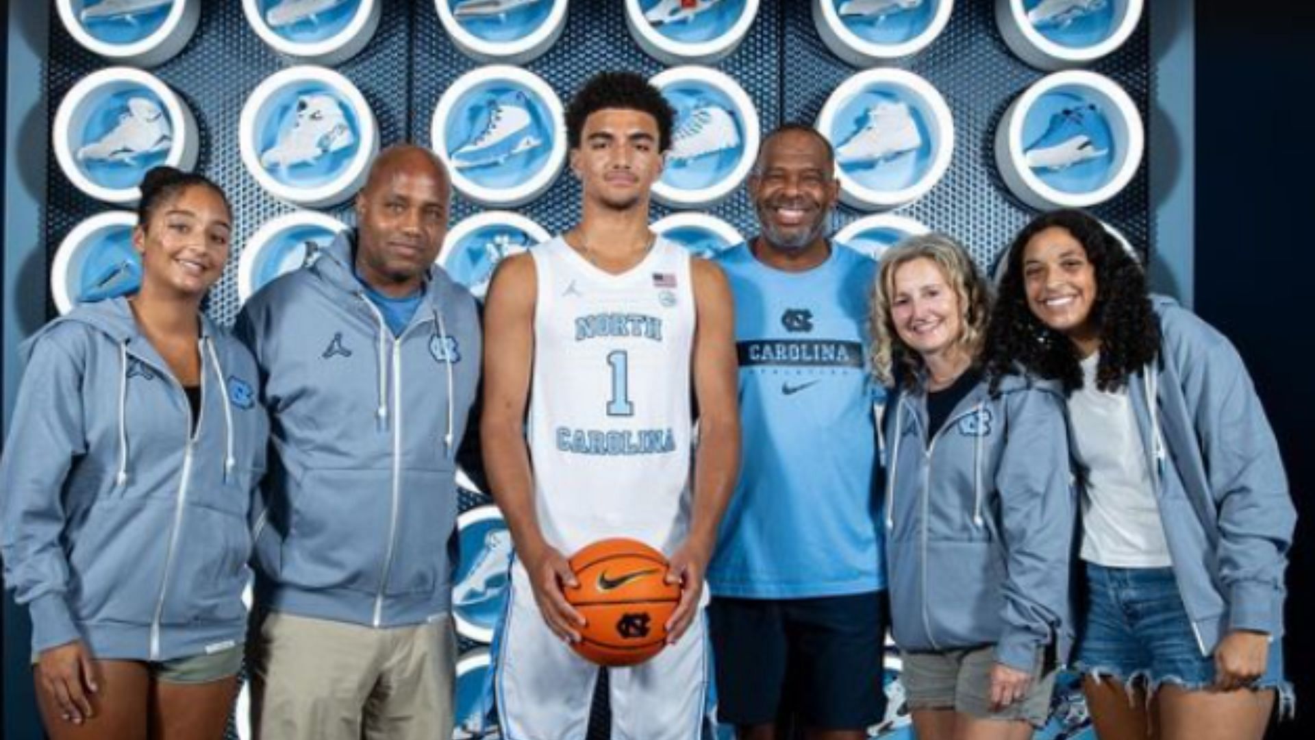 Derek Dixon poses with his family and UNC coach Hubert Davis (Image Source: @thederekdixon/Instagram)