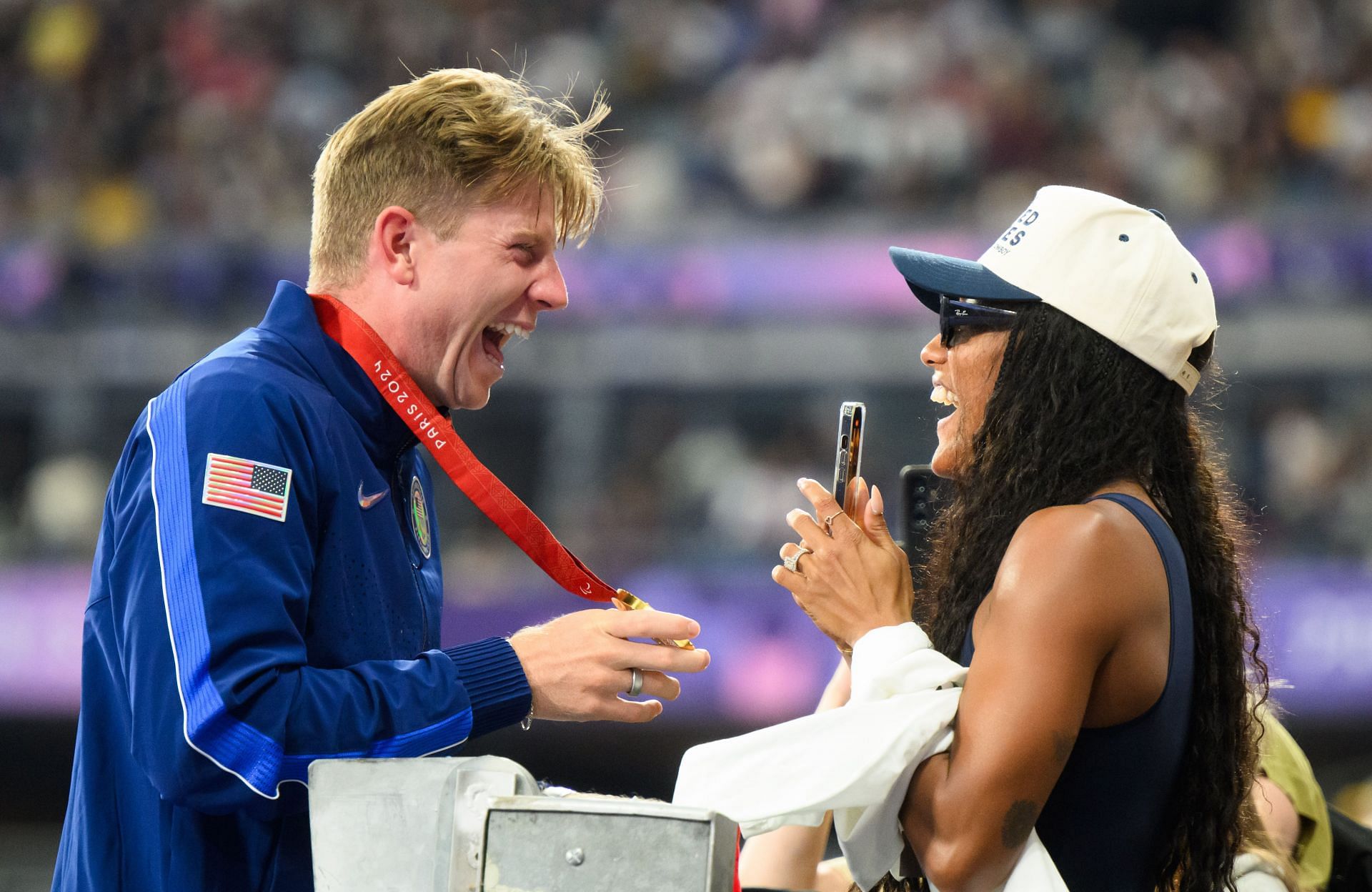 Hunter Woodhall celebrates his Paralympics gold medal with Tara Davis-Woodhall at the Paris Paralympics 2024 [Image Source: Getty]