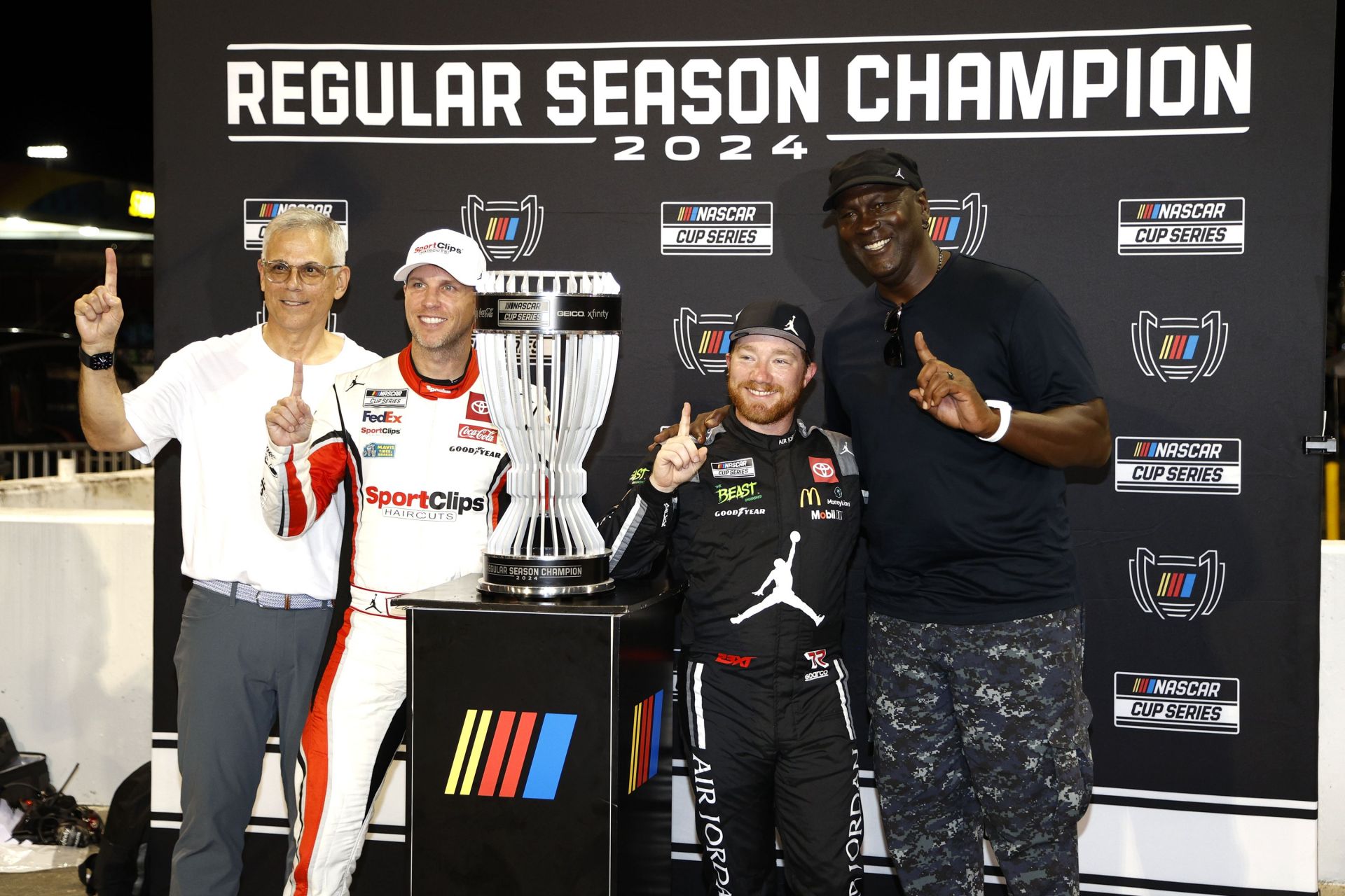 Tyler Reddick (2nd from R) celebrates with CurtisPolk (L) and Team 23XI Racing&#039;s co-owners Denny Hamlin (2nd from L) and Michael Jordan [R] after winning the 2024 regular season championship. Source: Getty Images