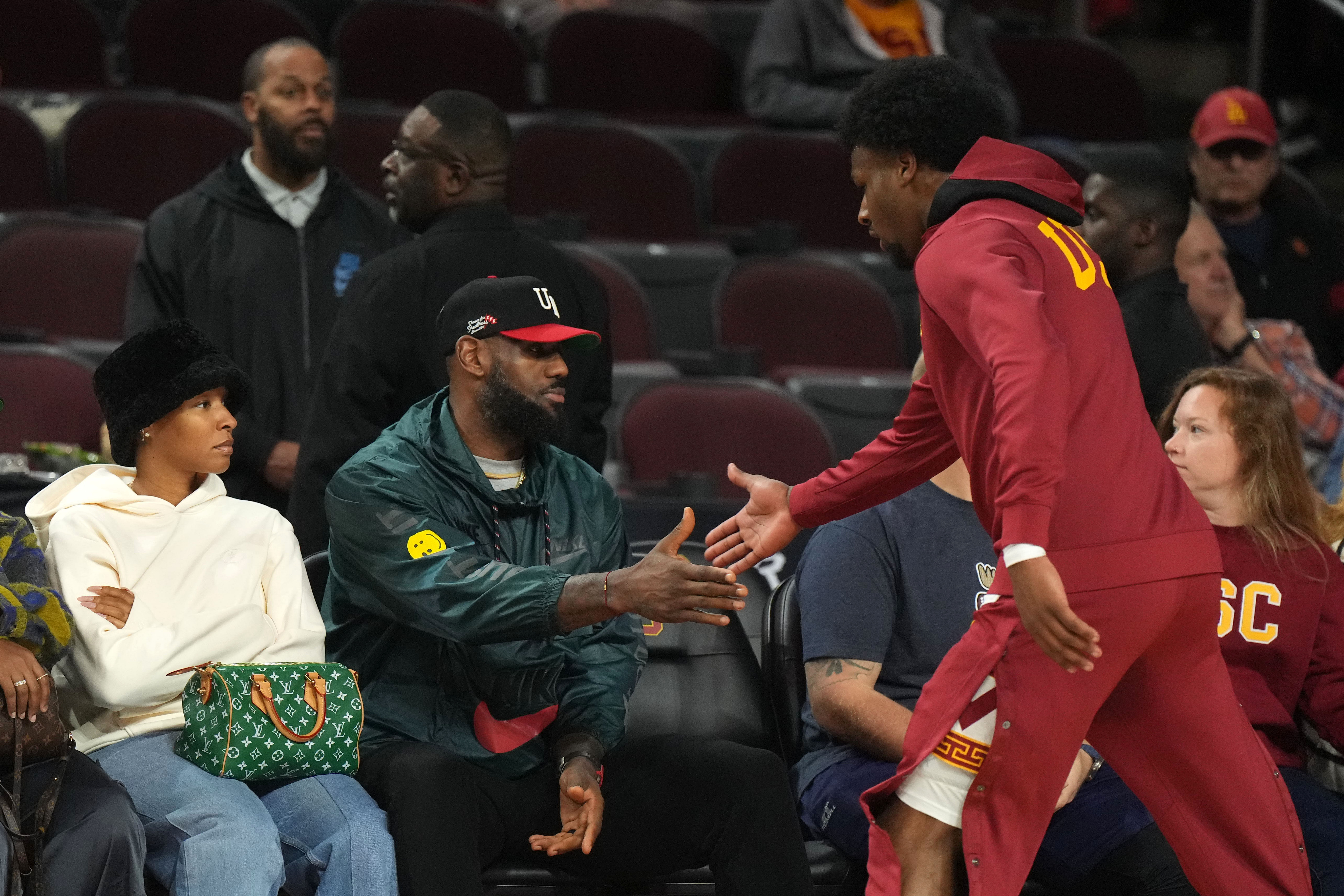 Bronny James is greeted by father LeBron James during the game against the Washington State Cougars at Galen Center. Photo Credit: Imagn