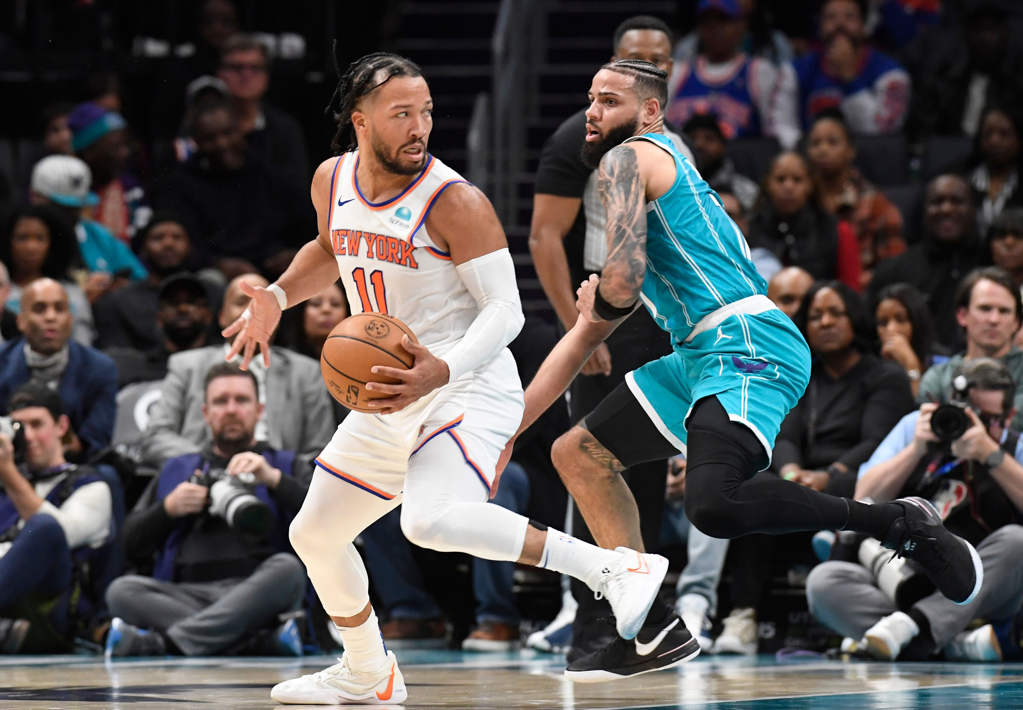 New York Knicks guard Jalen Brunson moves past Charlotte Hornets forward Cody Martin at the Spectrum Center. (Credits: IMAGN)